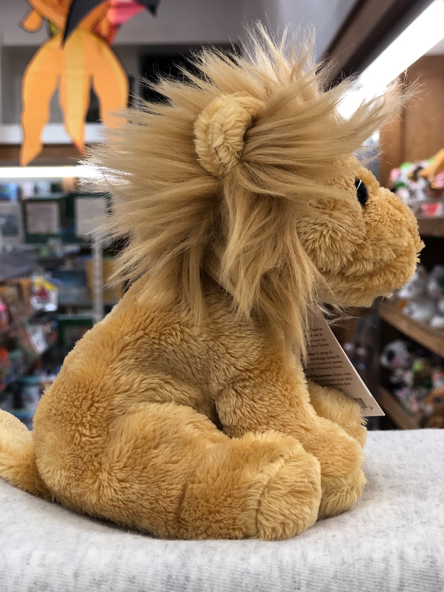 Soft and cuddly Charlie Bears Cuddle Cub Lion plush toy with fluffy mane, perfect for babies, sitting on display in toy store