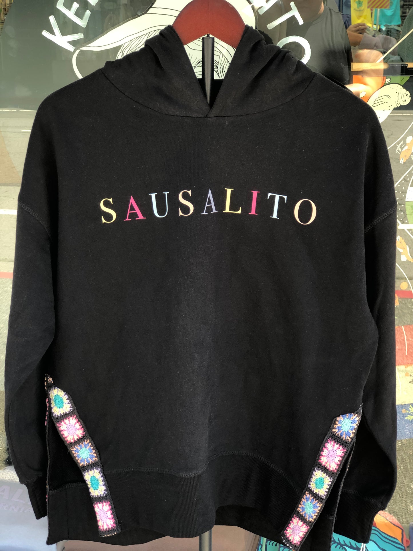 Black sweatshirt with 'SAUSALITO' text and colorful embellishments.