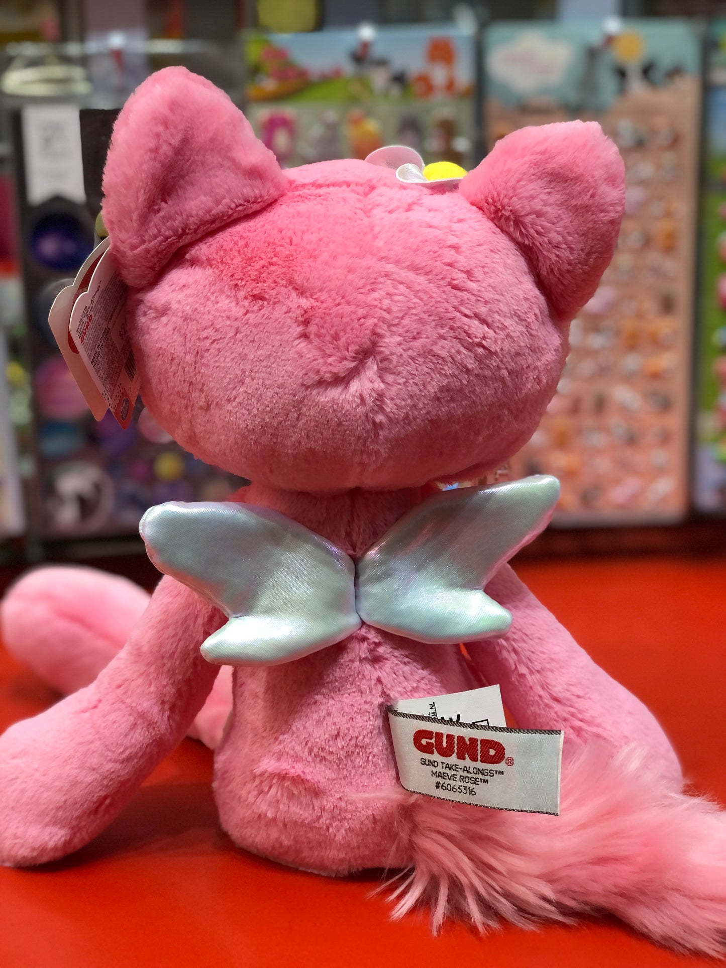 Pink Gund Take-Along Maeve Rose Fairy Cat plush with silver wings, fluffy tail, and embroidered details, sitting on display