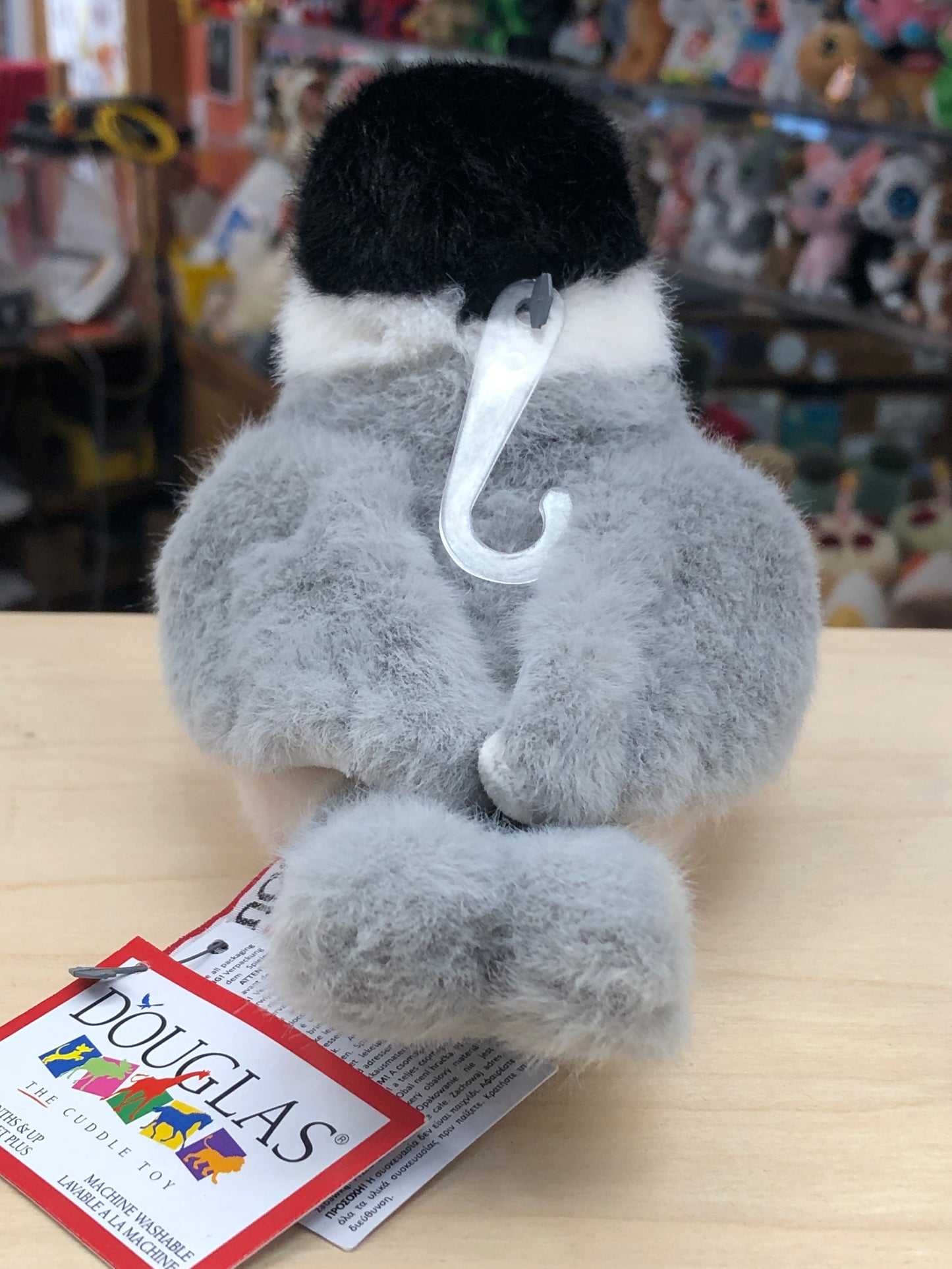 Realistic Douglas Chipper Chickadee plush toy with black cap, white markings, and gray body, displayed with product tag