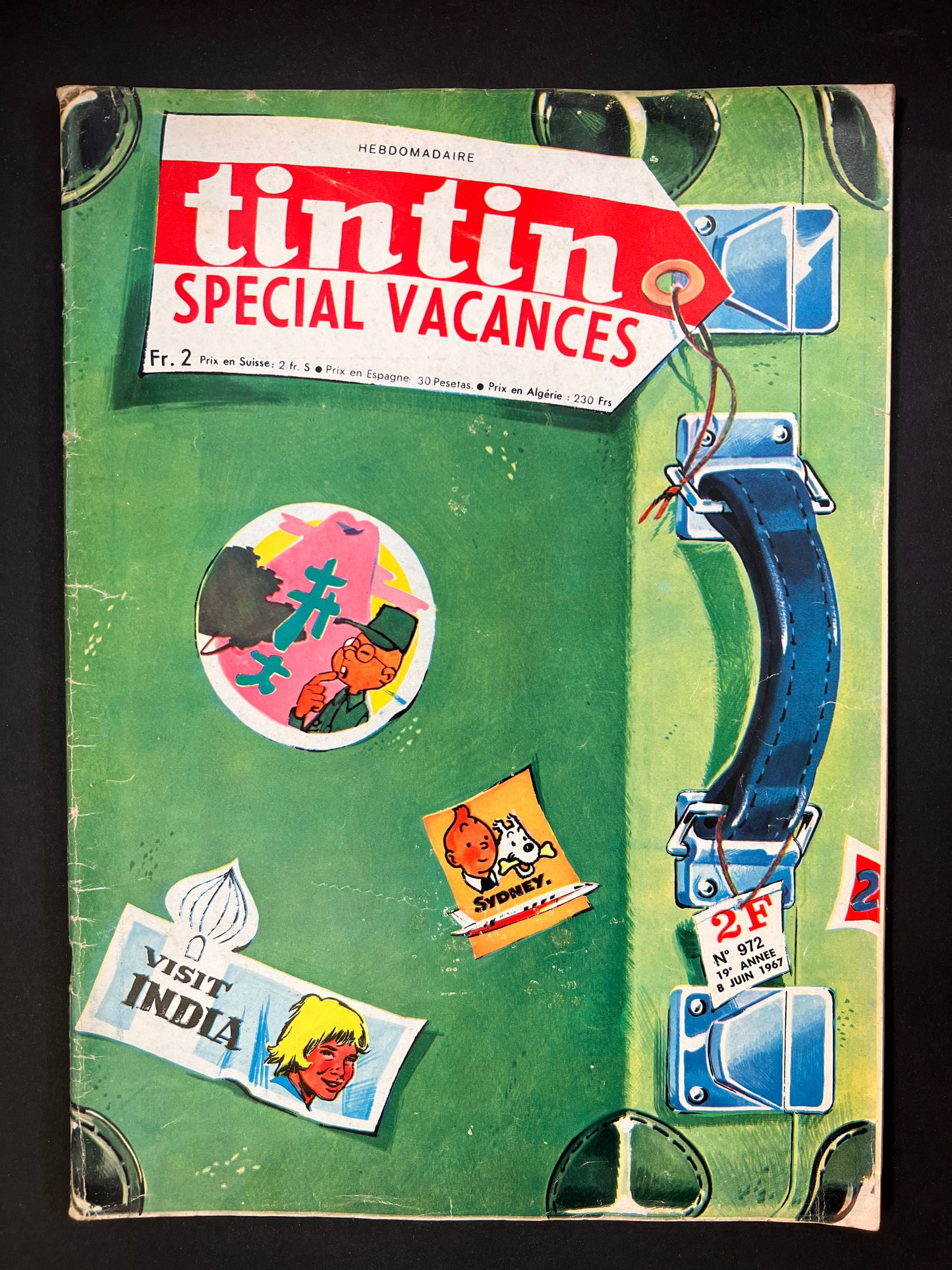 Tintin magazine cover 1967, green suitcase with comic stickers, "Special Vacances" issue featuring travel-themed illustrations