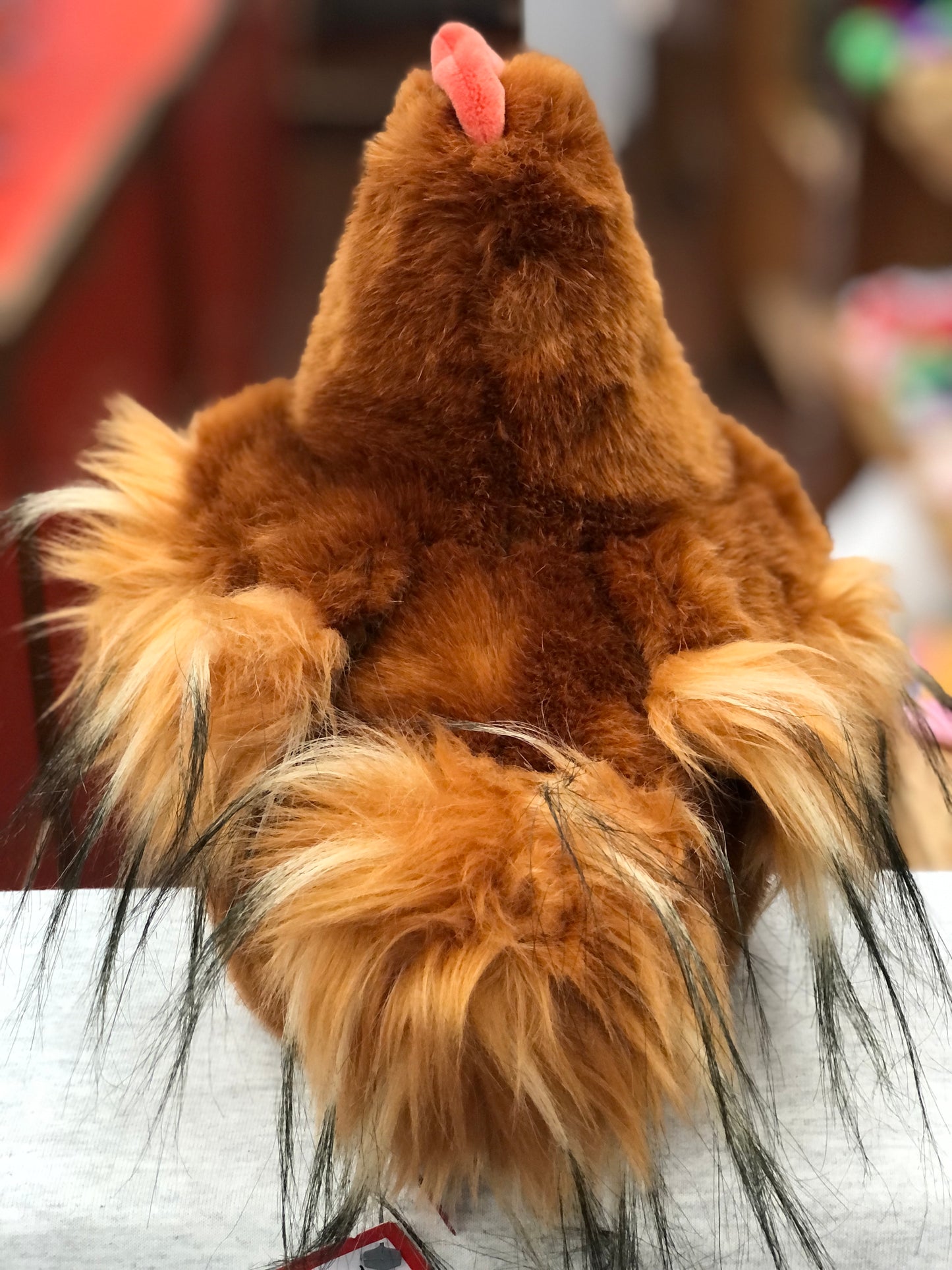 Fluffy brown Hector the Hen plush toy, viewed from behind, with pink comb visible, ready for playtime adventures