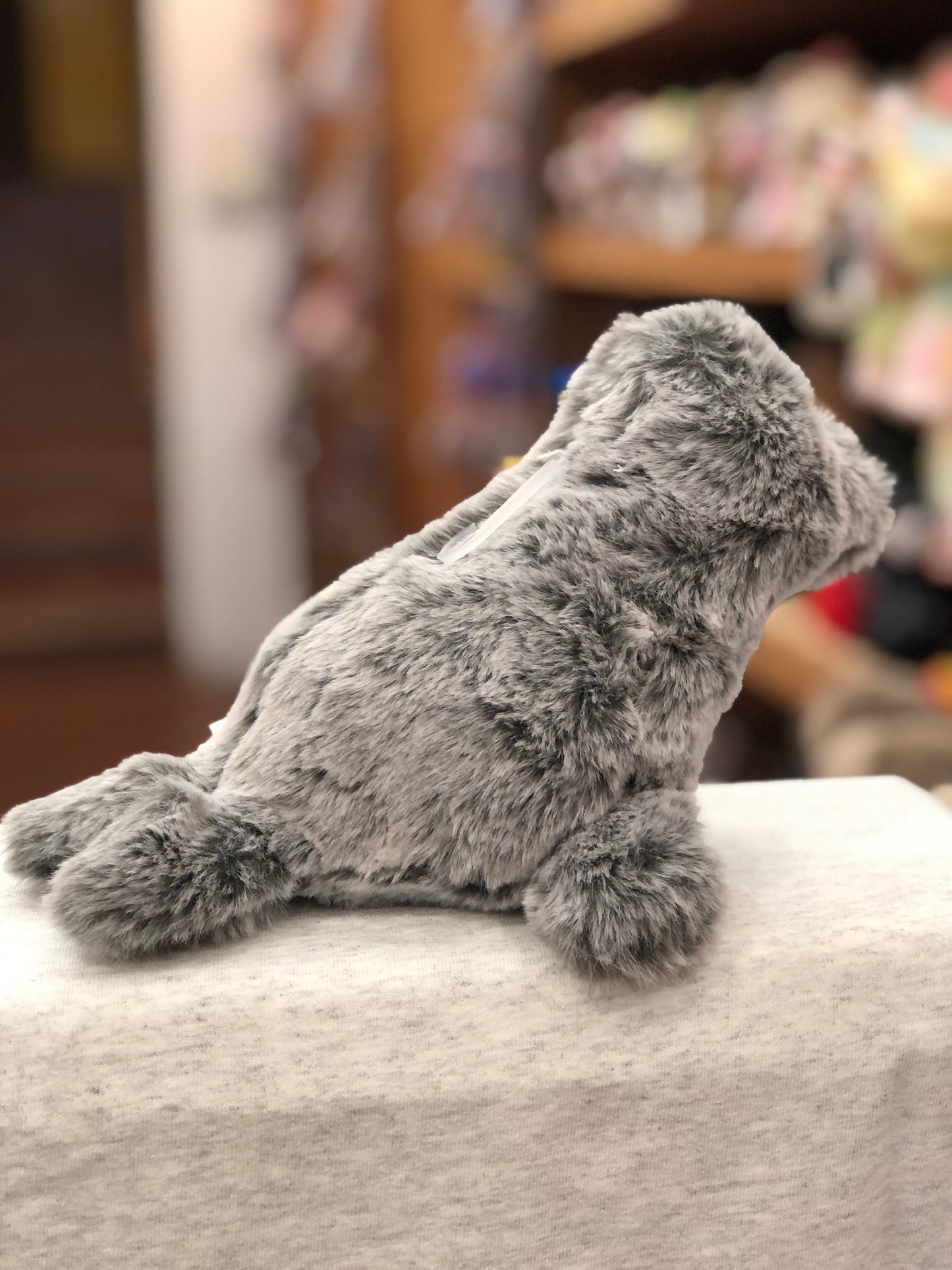 Soft gray Mary Meyer Marshmallow Zoo seal plush toy sitting on fabric, showcasing its cuddly texture and realistic shape