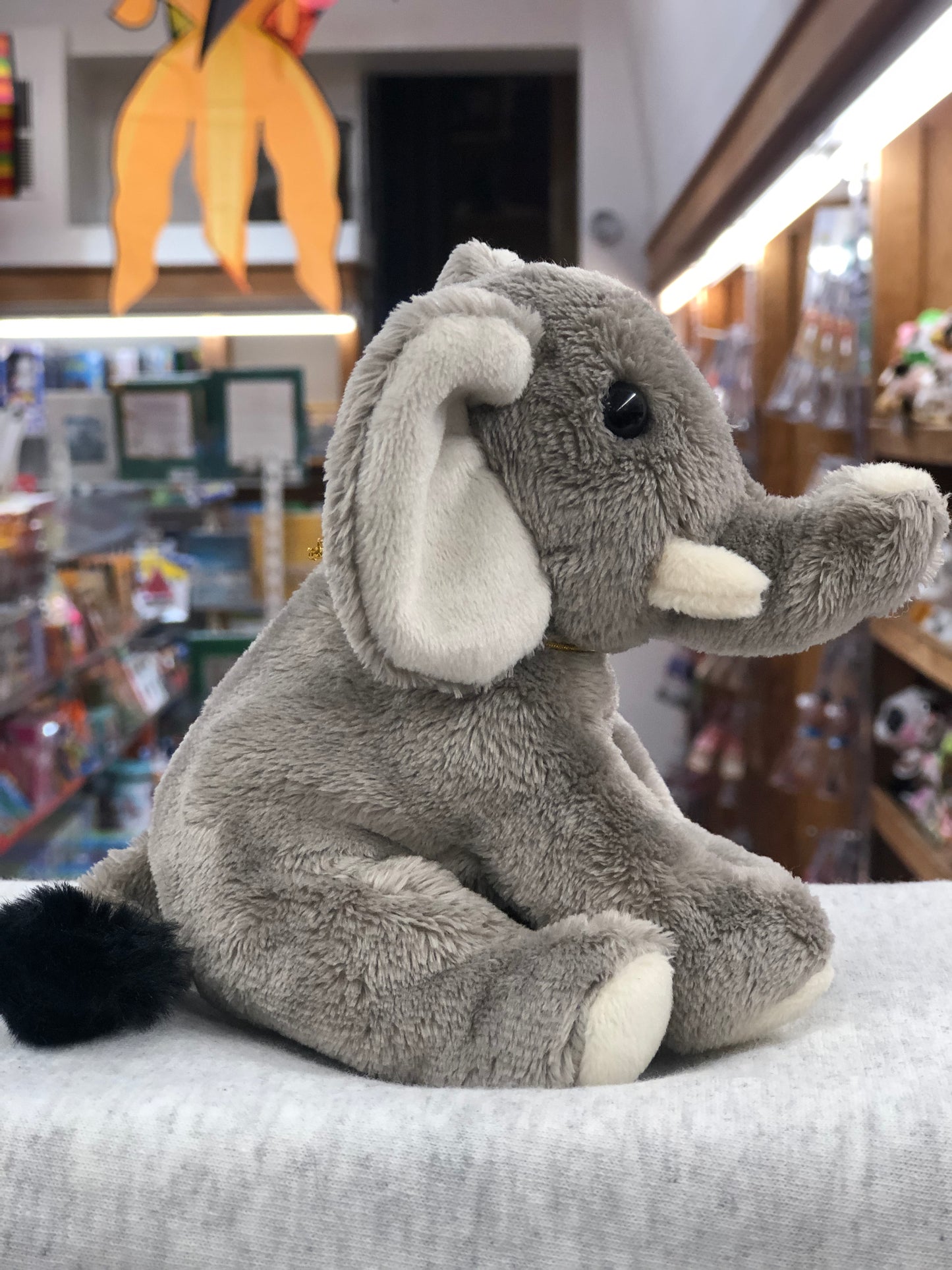 Soft gray Charlie Bears Cuddle Cub Elephant plush toy sitting on display in a store, perfect for babies and small children