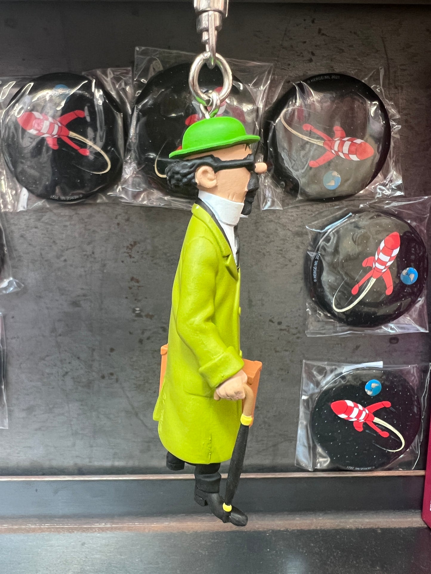 Professor Calculus keychain figure in green coat and hat, displayed with rocket-themed badges, 7cm mini collectible