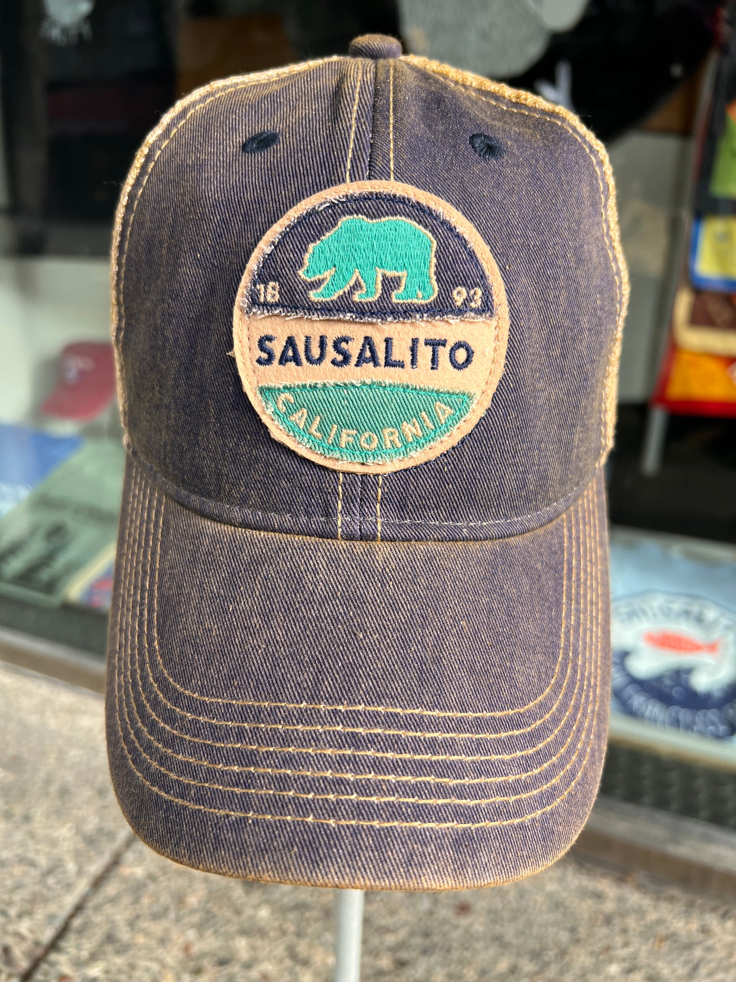 Navy trucker cap with embroidered Sausalito California logo featuring green grizzly bear and '1893' incorporation date