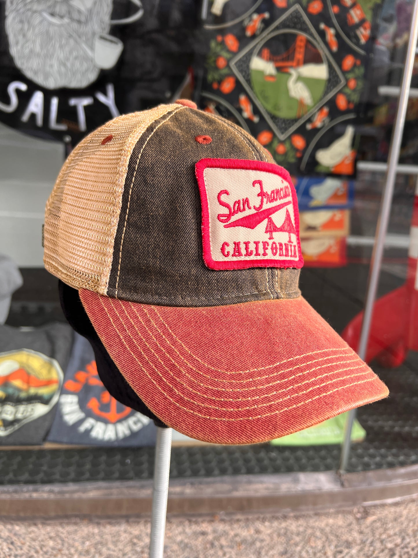 Vintage-style San Francisco trucker hat with Golden Gate Bridge patch, brown front, red brim, and beige mesh back
