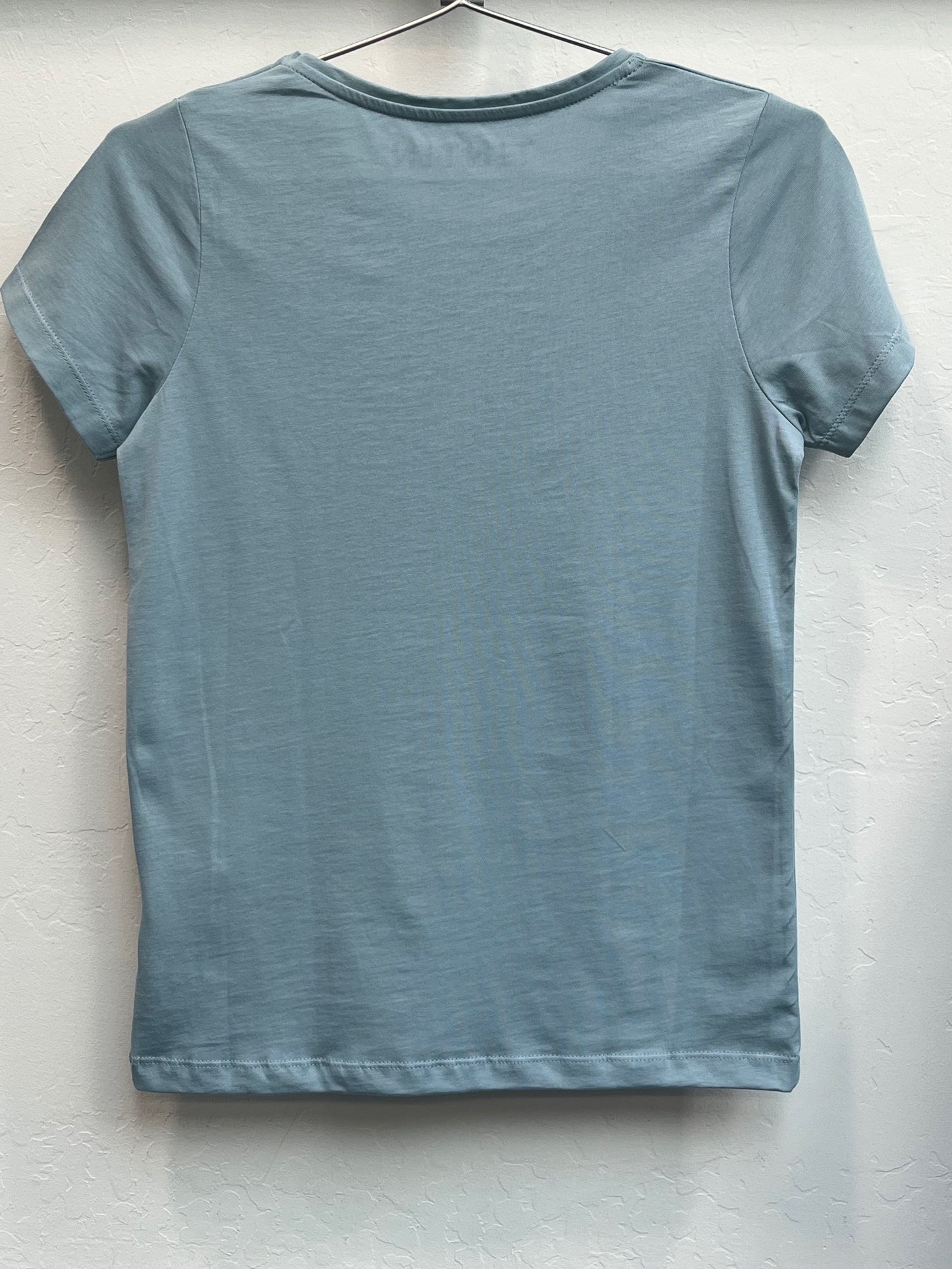 Light blue women's cotton t-shirt with round neck and short sleeves, hanging on display