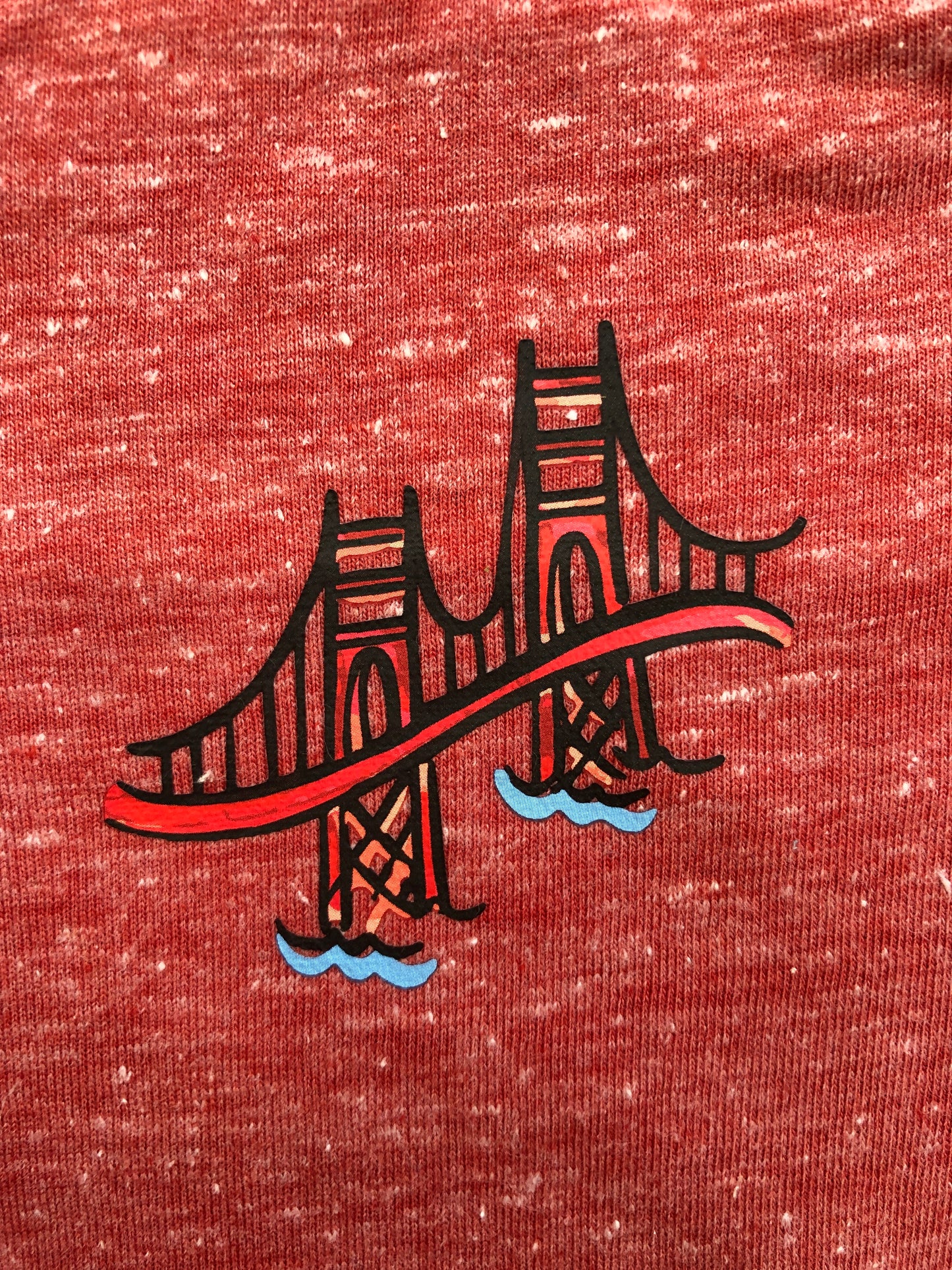 Cartoon Golden Gate Bridge print on heather red baby onesie, showcasing iconic San Francisco landmark
