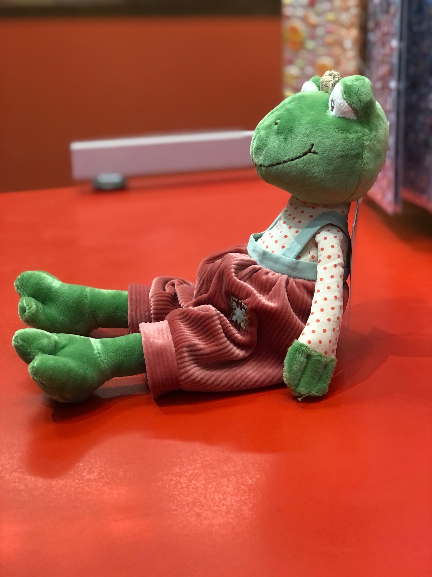 Bukowski Bears Prince Frog plush toy in polka dot shirt and red overalls, wearing golden crown, sitting on red surface