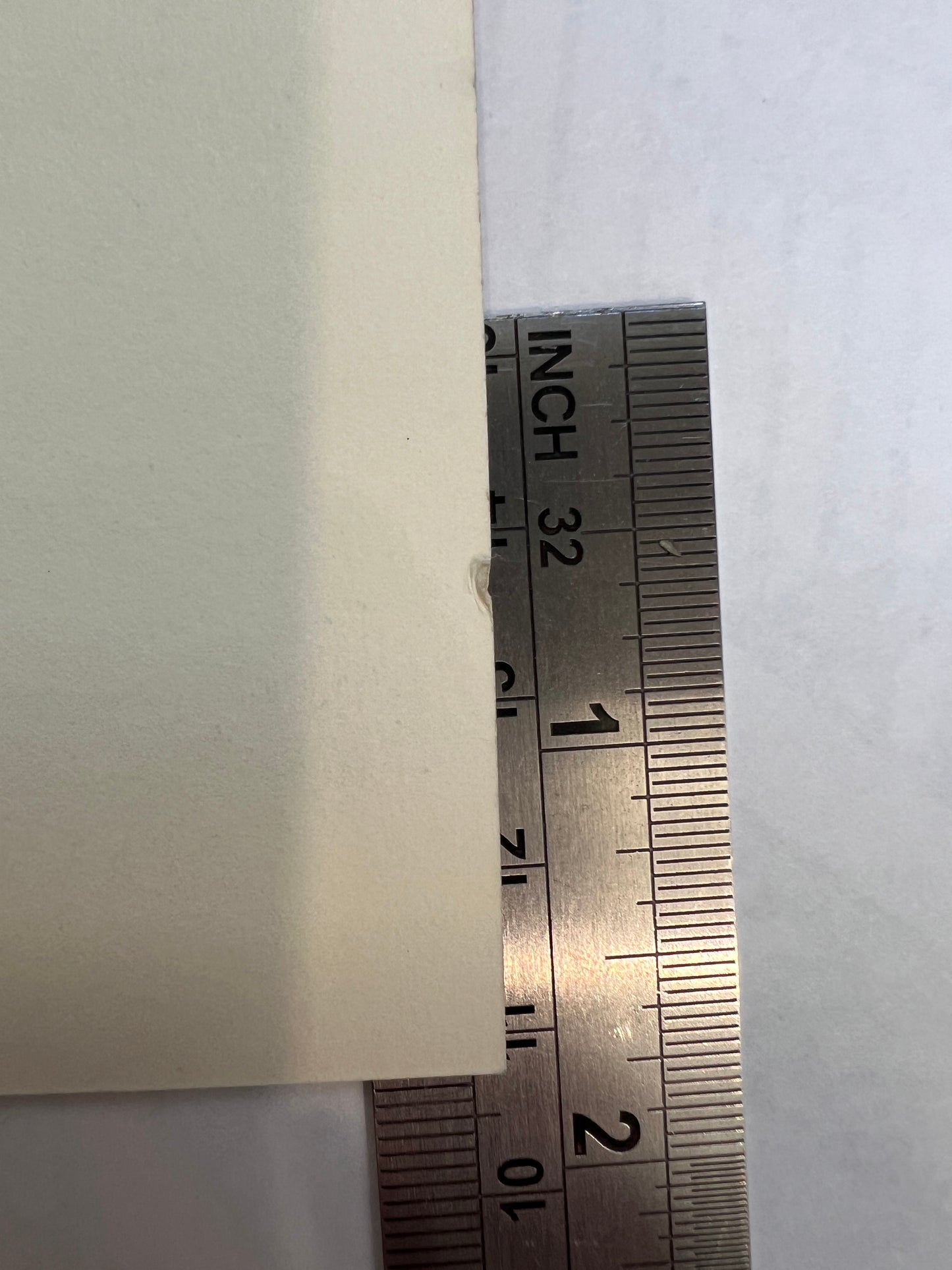 Metal ruler measuring edge of Tintin Red Sea Sharks poster, showing thickness of high-quality paper stock