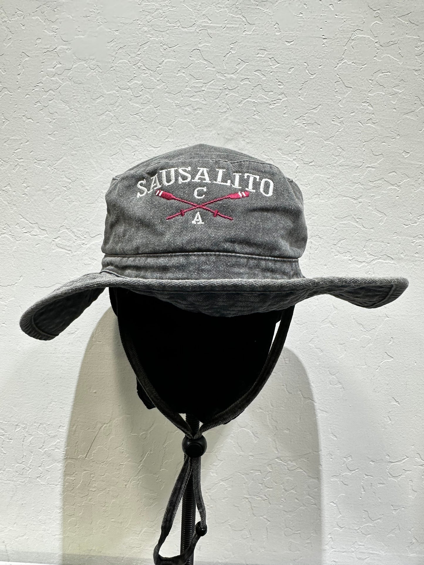 Washed cotton Sausalito bucket hat with crossed oars logo, wide brim, and adjustable chin cord against white background