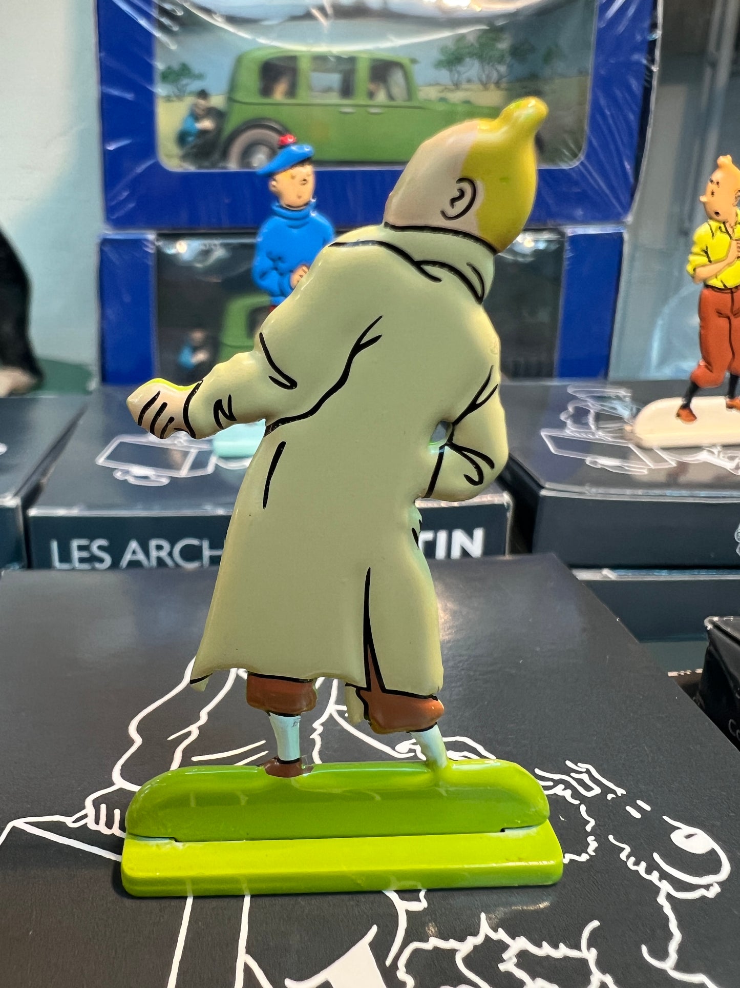 Tintin metal figure in trenchcoat, part of "The Seven Crystal Balls" collection, displayed with other character models