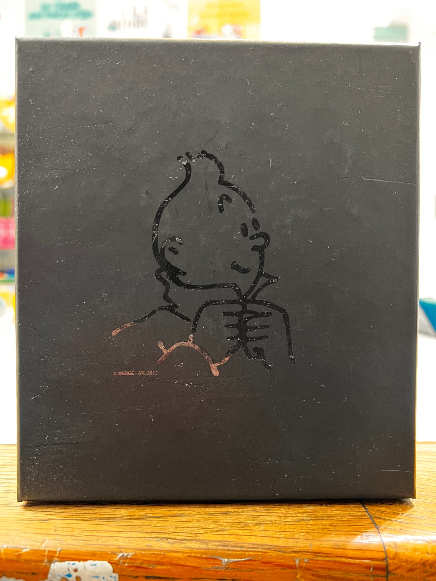 Black gift box for Tintin Limoges porcelain bust, featuring outlined Tintin image buttoning collar on front