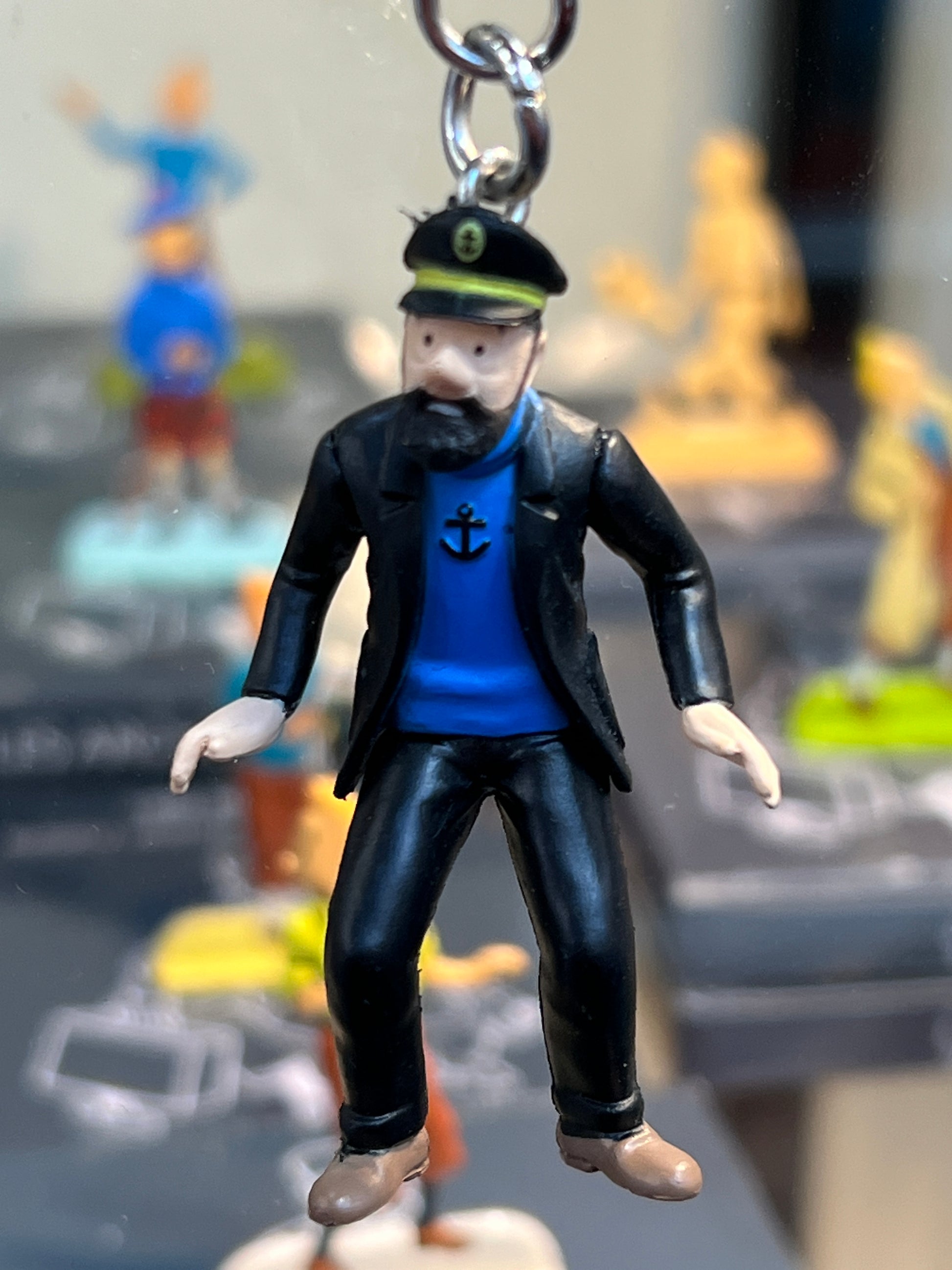Captain Haddock keychain figure with surprised expression, wearing black coat and blue shirt with anchor, attached to metal ring