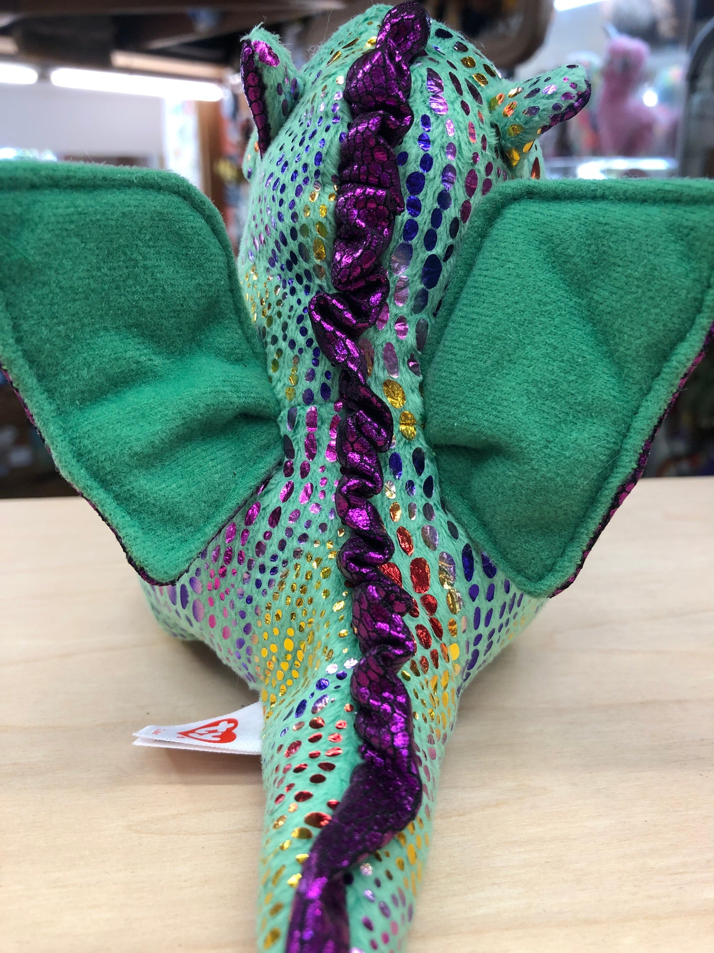 Colorful Ty Beanie Boo Cinder Dragon plush toy with sparkly green body, purple spine, and soft green wings