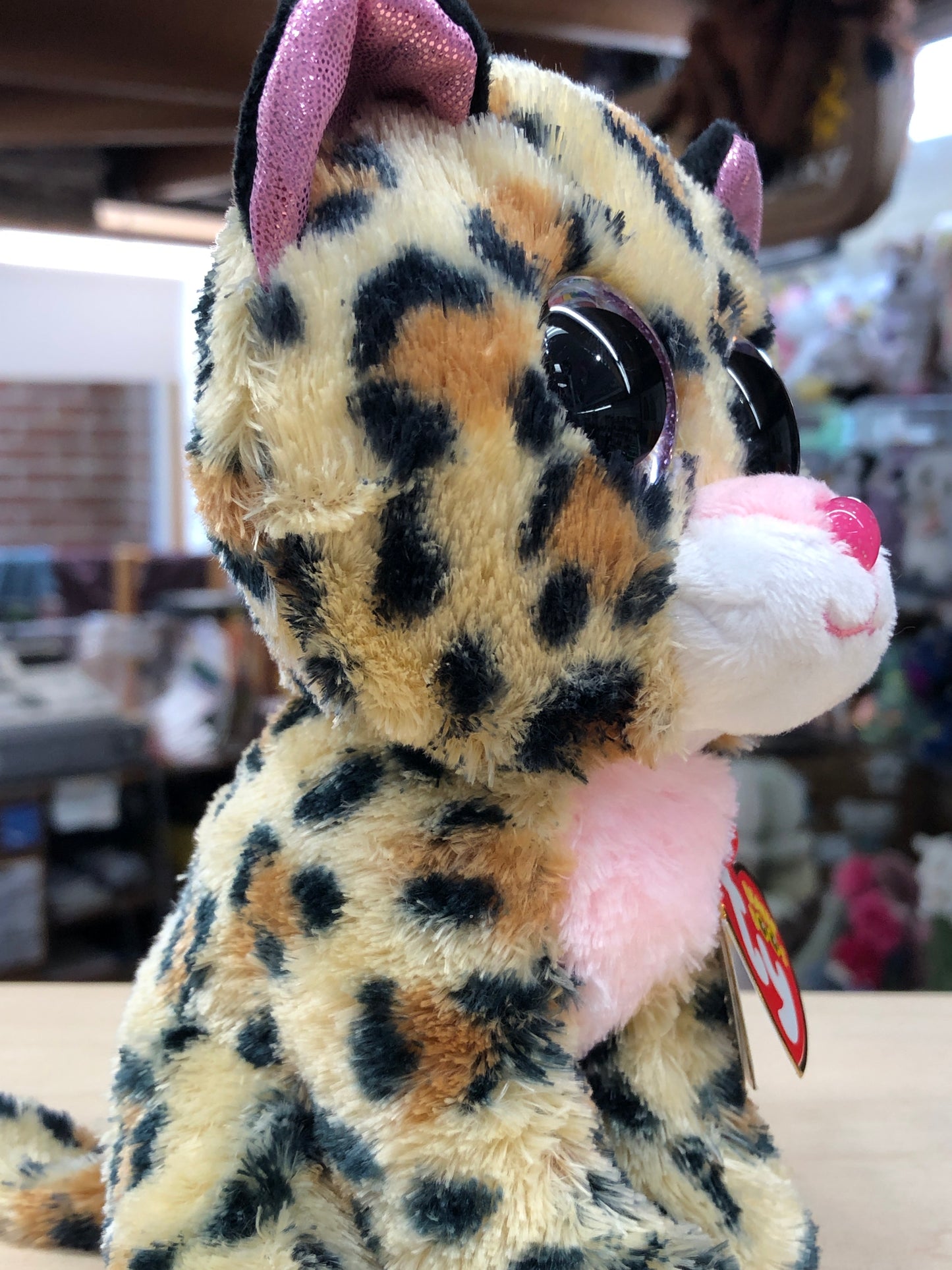 Ty Beanie Boo Livvie leopard plush toy with brown spots, pink ears and nose, large sparkly eyes, soft fur, and Ty heart tag