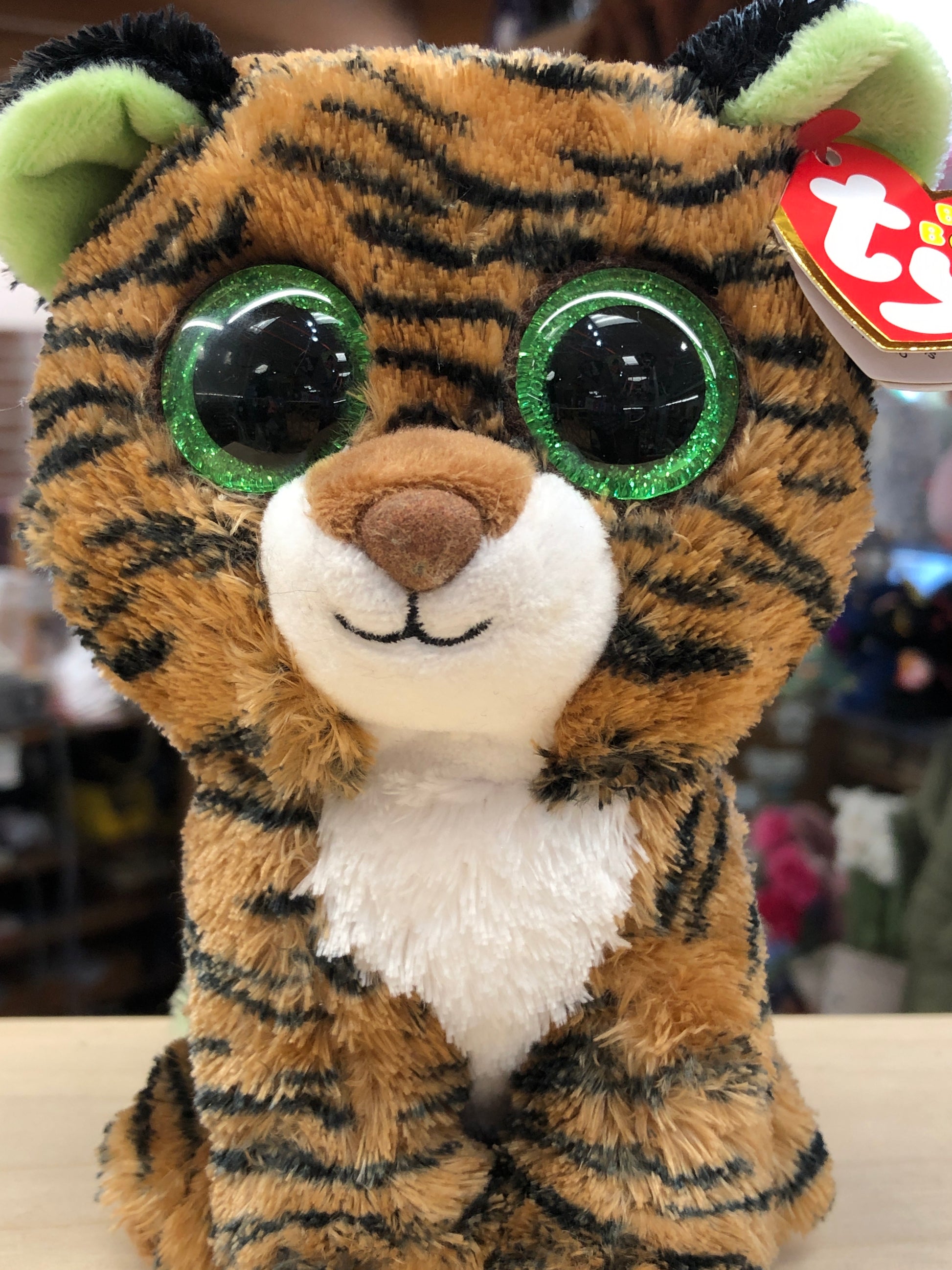 Ty Beanie Boo Tiggy plush tiger with green eyes, brown striped fur, and white chest, featuring unique green ears