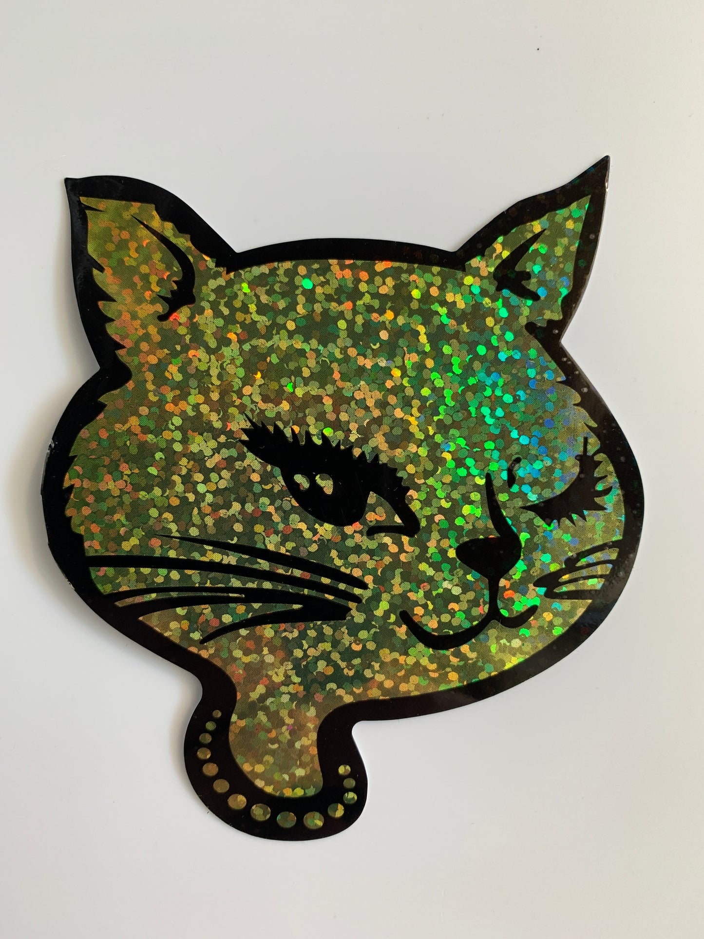 Winking cat glitter sticker in green holographic sparkle, shaped outline with black details on white background
