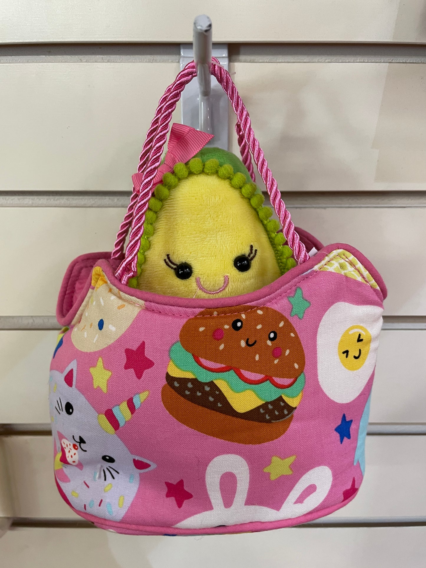 Colorful kids' handbag with food-themed pattern and plush avocado toy, featuring pink straps and whimsical designs