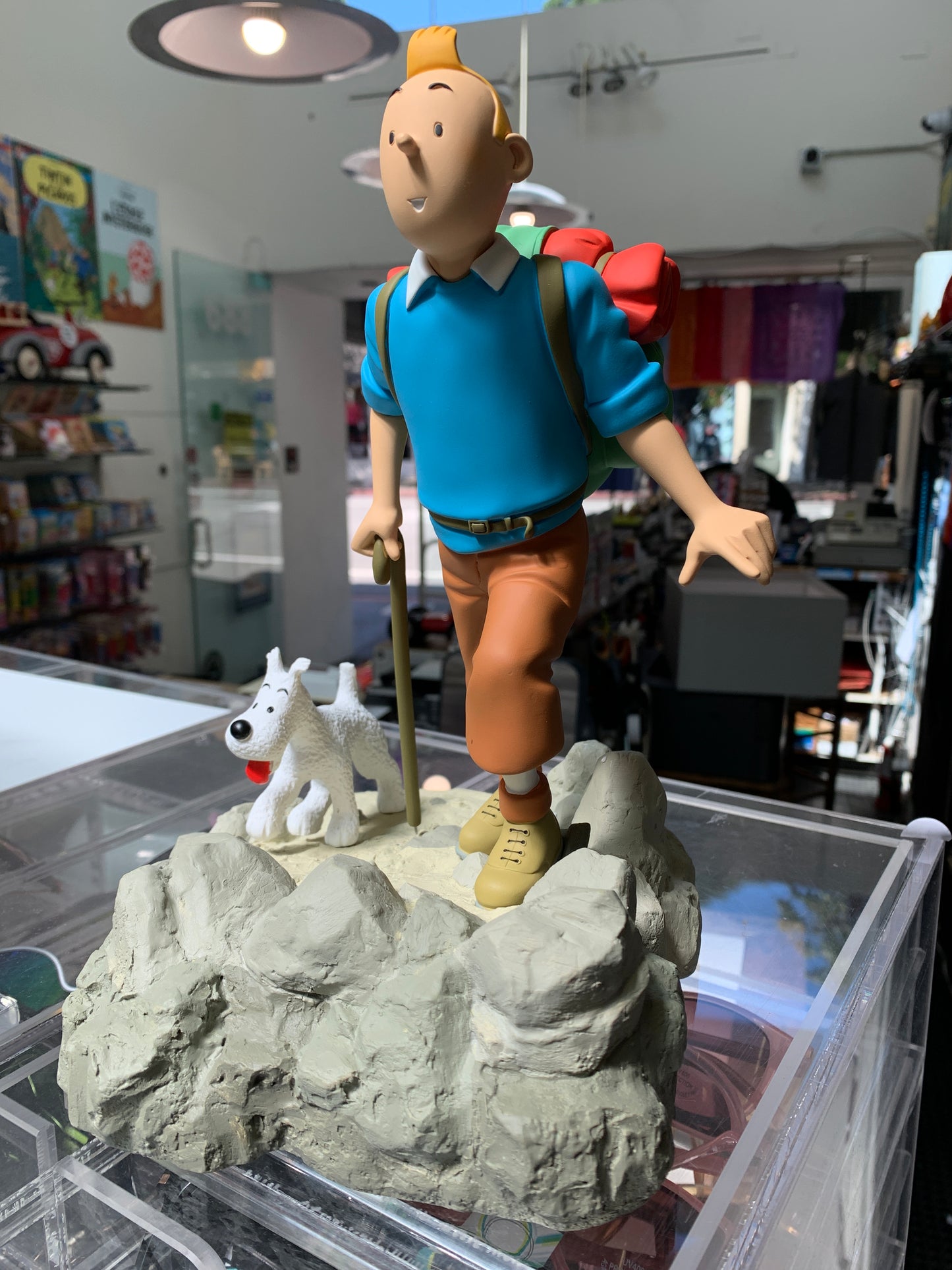 Tintin hiker statuette from Destination Moon, with backpack and dog, on rocky base in store display