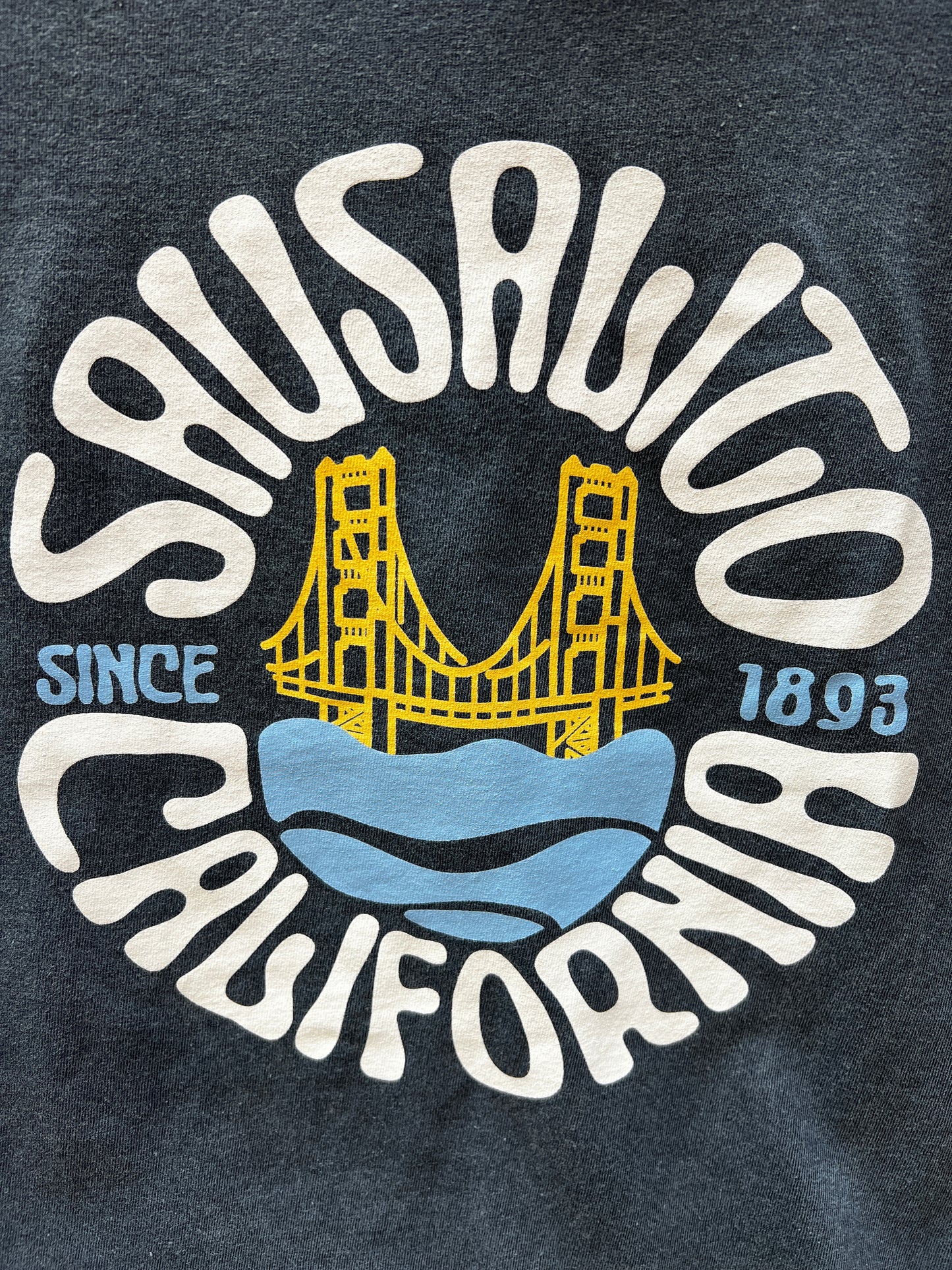 Groovy Sausalito California t-shirt design featuring Golden Gate Bridge, established 1893, on denim-colored fabric