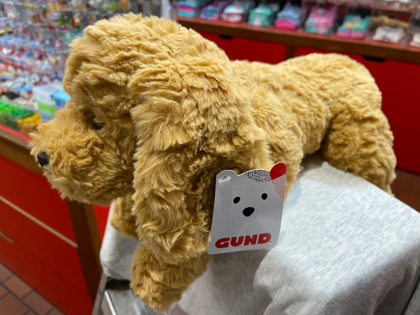 Gund Muttsy beige plush dog toy with floppy ears on display, showcasing soft fur and 14-inch size for cuddling