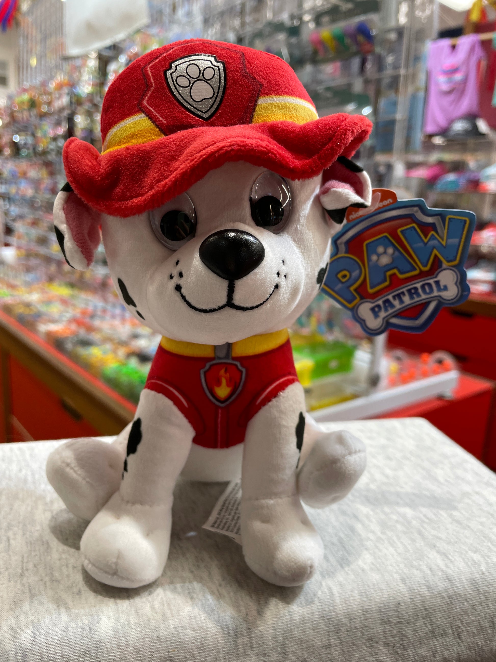 Gund Paw Patrol Marshall plush toy, dalmatian in red fireman uniform with hat, sitting on display in toy store