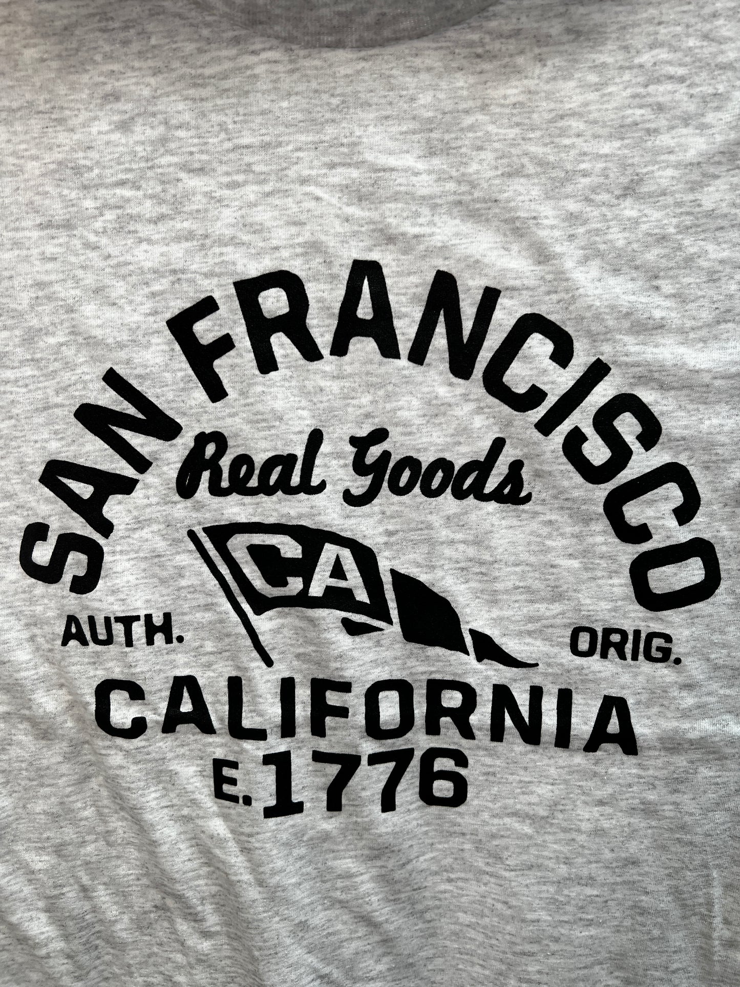 San Francisco Real Goods unisex t-shirt design, featuring black text and logo on heather gray cotton fabric