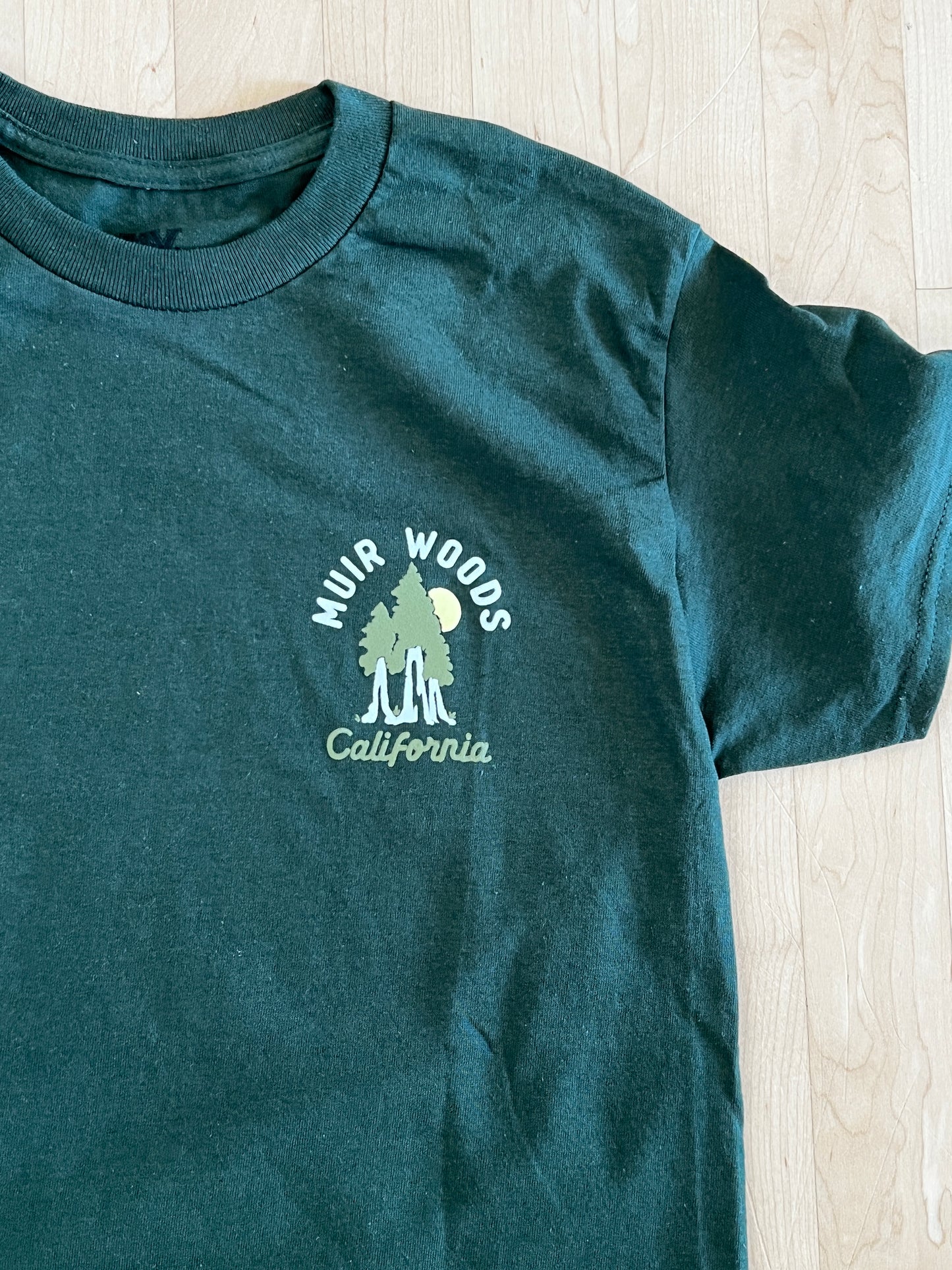 Green Muir Woods California t-shirt with redwood trees and sun logo on chest pocket, unisex cotton tee