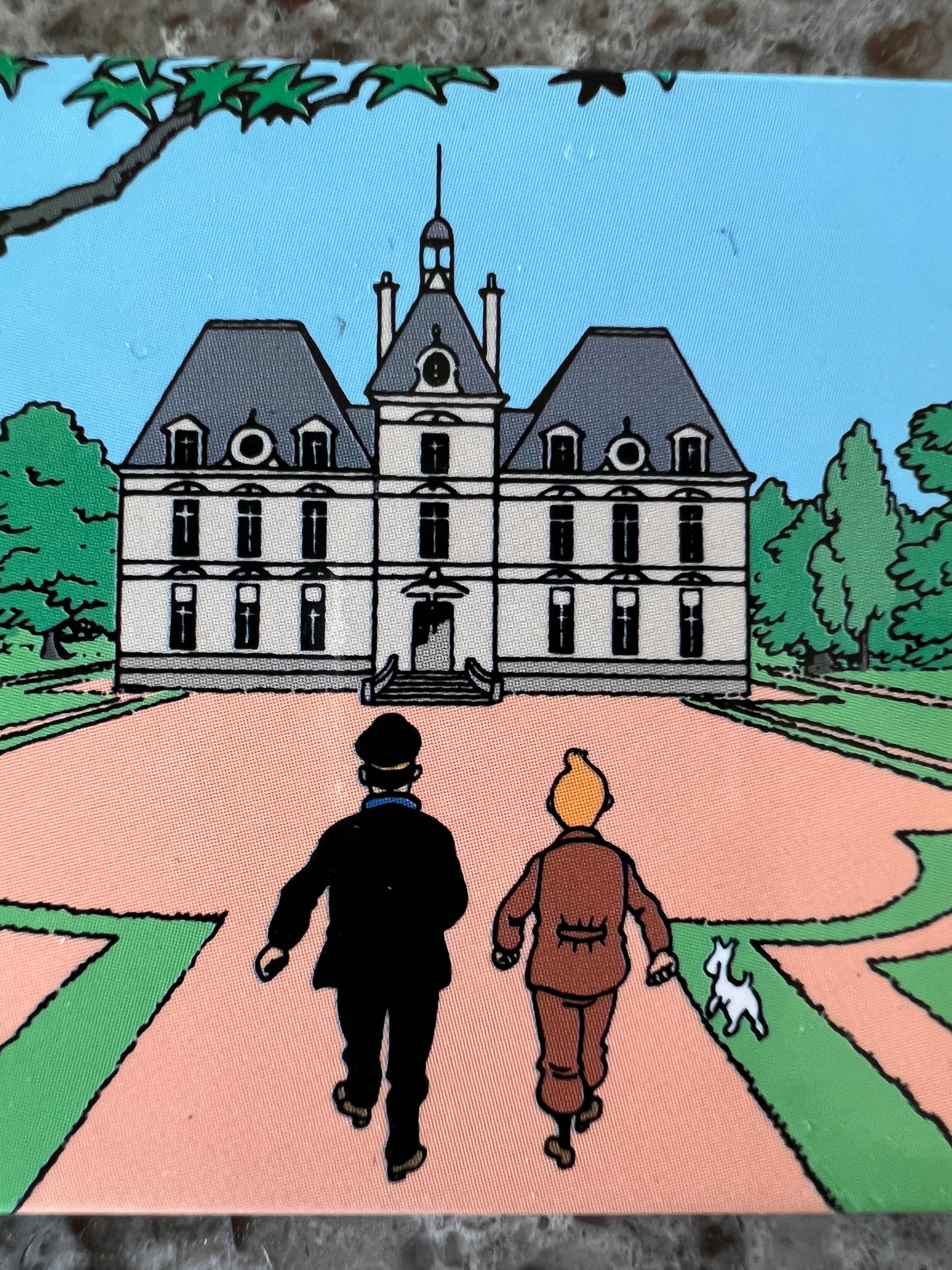Tintin characters approaching Marlinspike Hall on magnet, castle facade with grounds and small dog visible