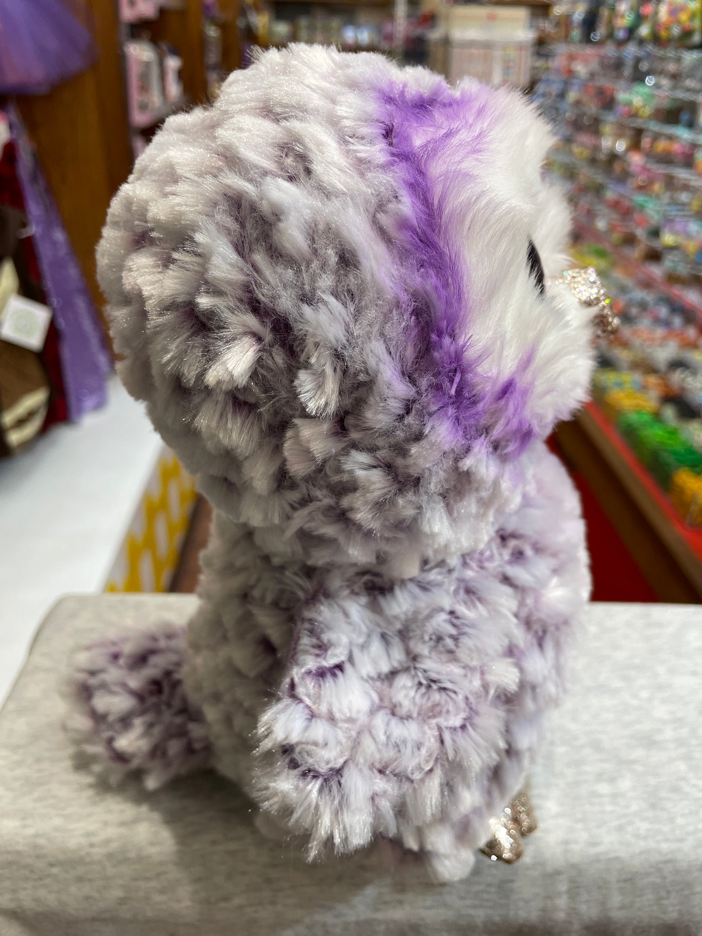 Ty Beanie Boo Moonlight owl plush toy, purple and white fluffy texture, glittery accents, in toy store display