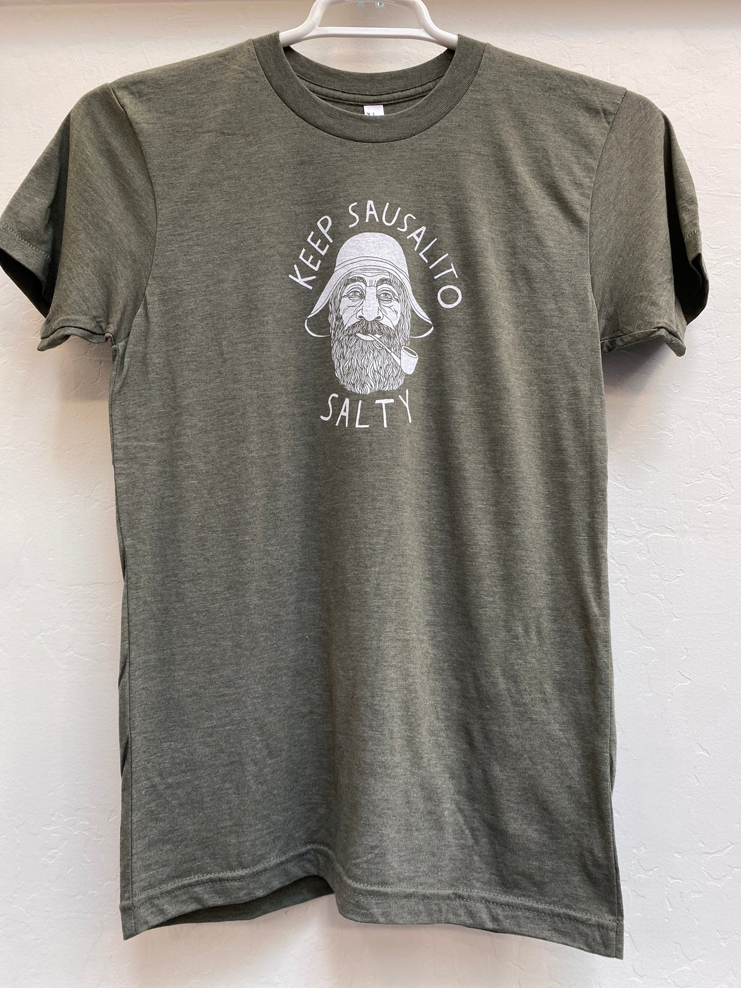 Green t-shirt with "Keep Sausalito Salty" slogan and illustration of bearded sailor, promoting local pride