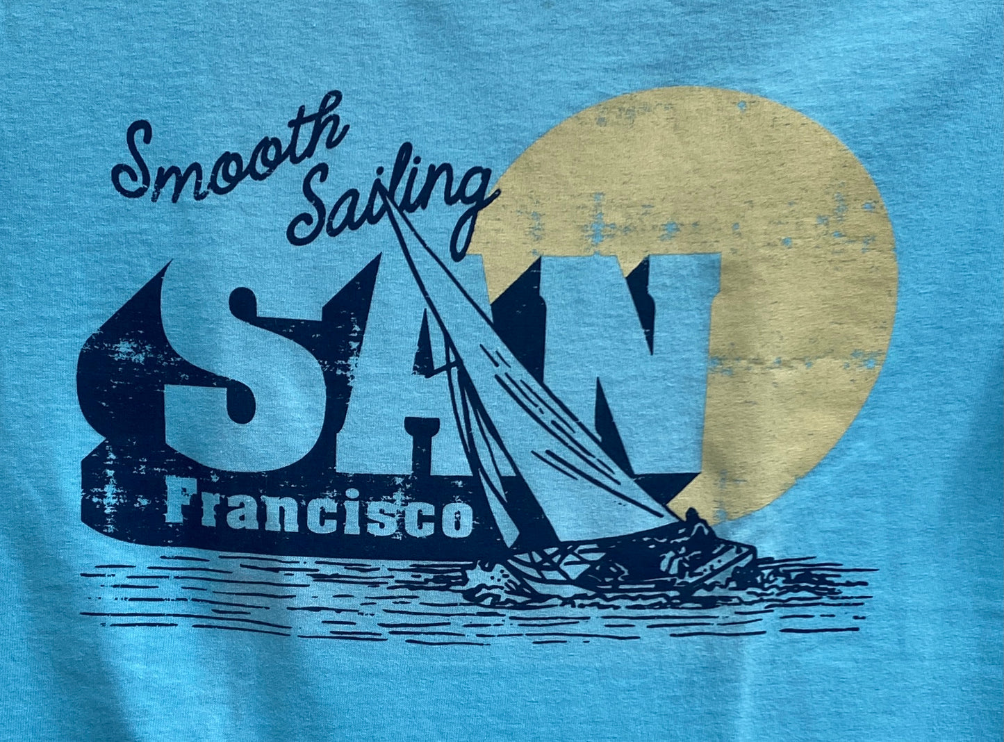 San Francisco 'Smooth Sailing' t-shirt design with sailboat silhouette and golden sun against blue background