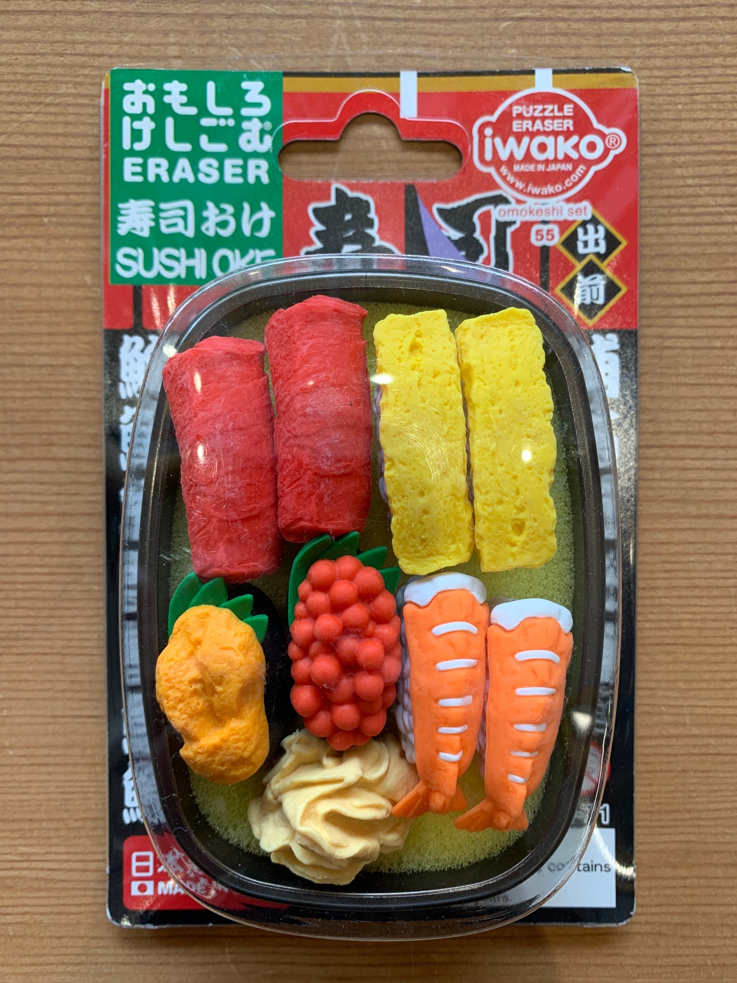 Sushi-shaped Japanese erasers in plastic bento box, including rolls, nigiri, and garnishes. Iwako brand puzzle eraser set #55.