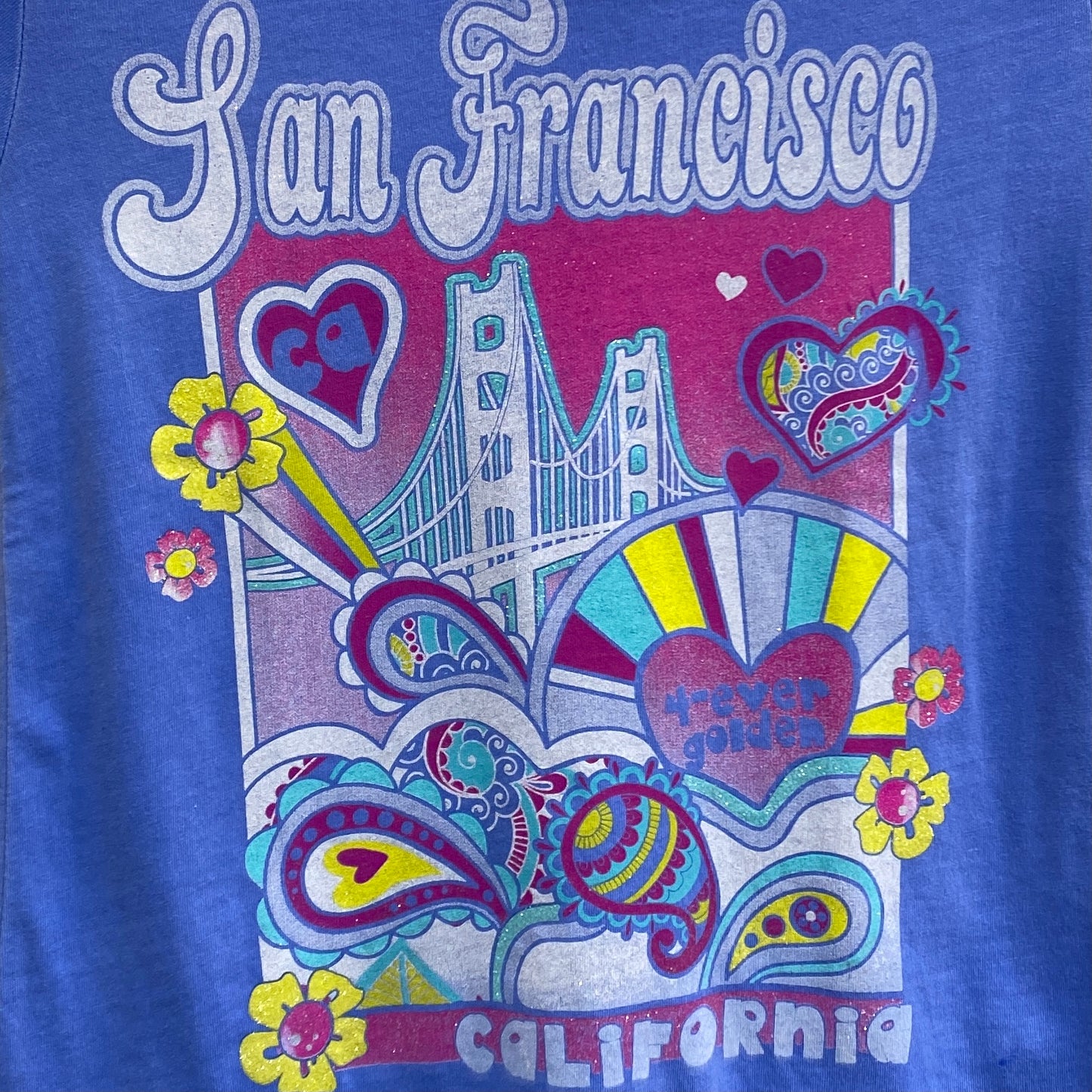Girls' San Francisco t-shirt with colorful psychedelic design featuring Golden Gate Bridge, hearts, and flowers on blue background