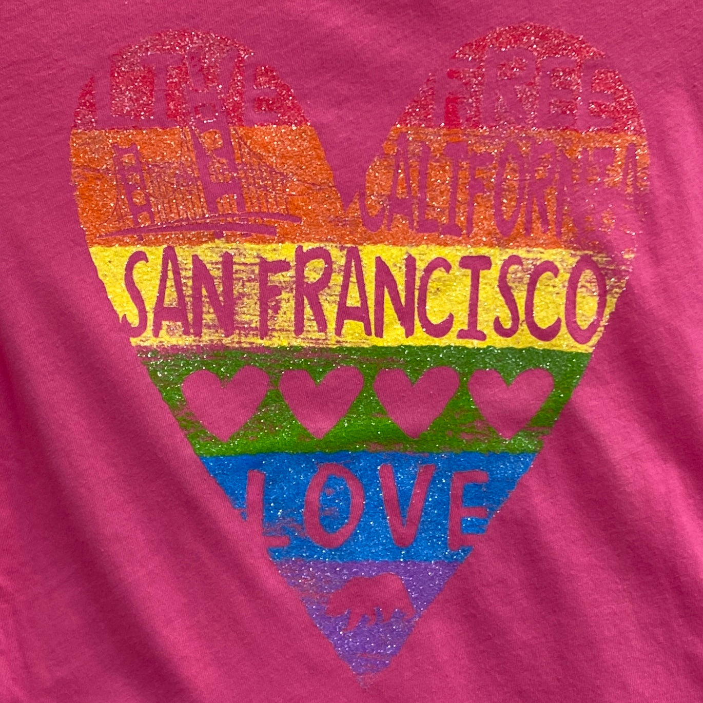 San Francisco girls' t-shirt with colorful heart design featuring city skyline, Golden Gate Bridge, and "Love" text on pink background
