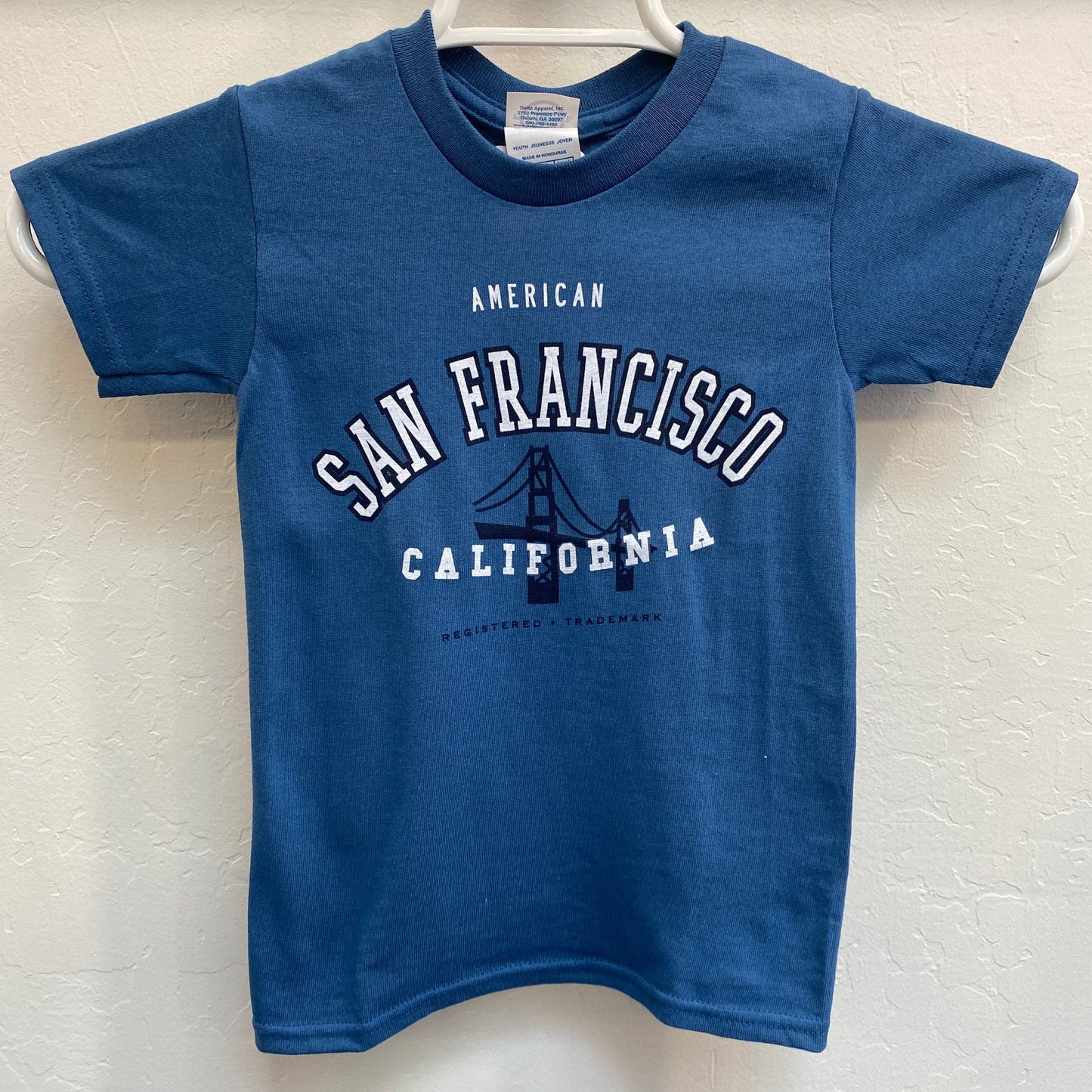 Blue kids' t-shirt with "San Francisco California" and Golden Gate Bridge design, showcasing American trademark for children's sizes