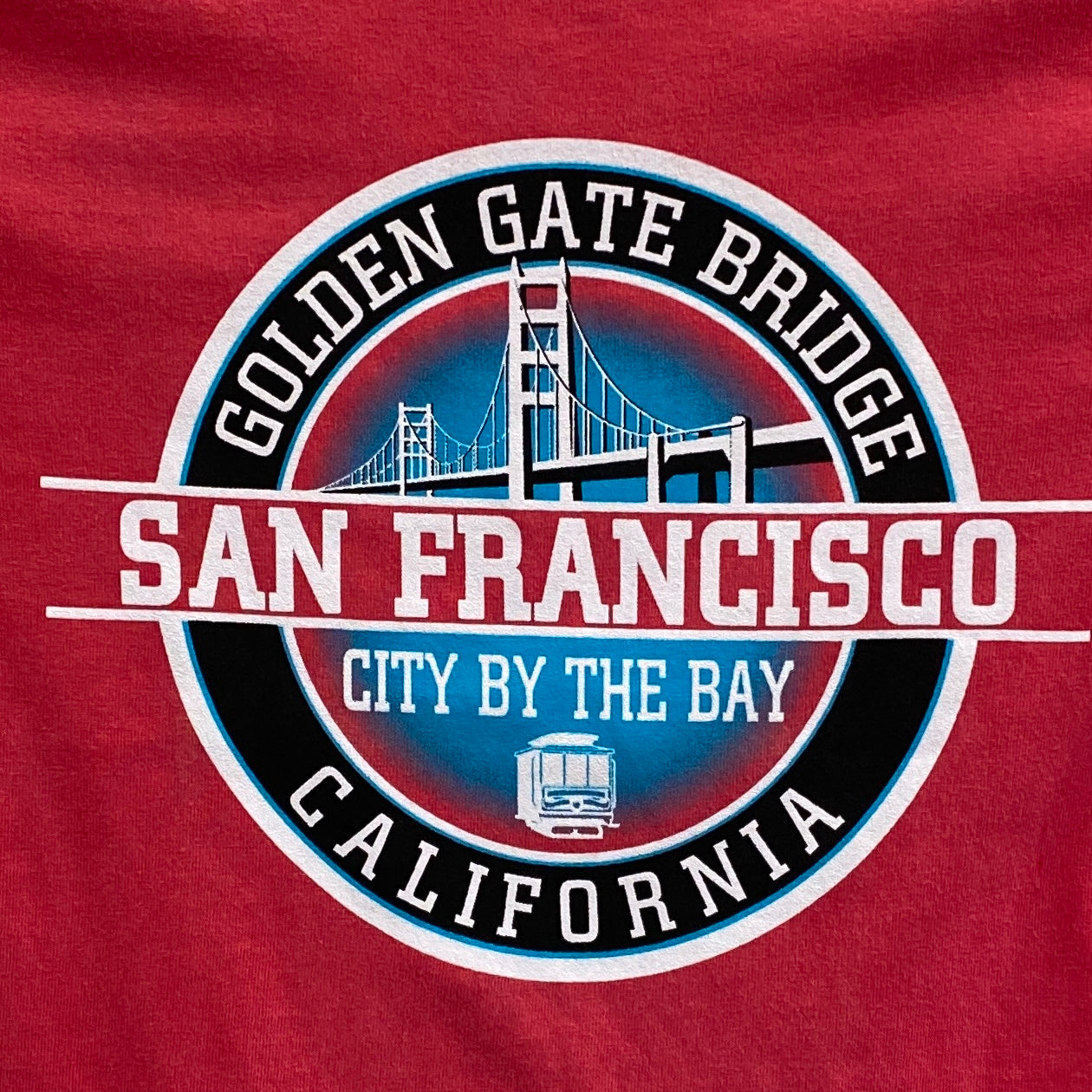 Red kids' t-shirt with San Francisco Golden Gate Bridge logo featuring bridge silhouette and cable car icon