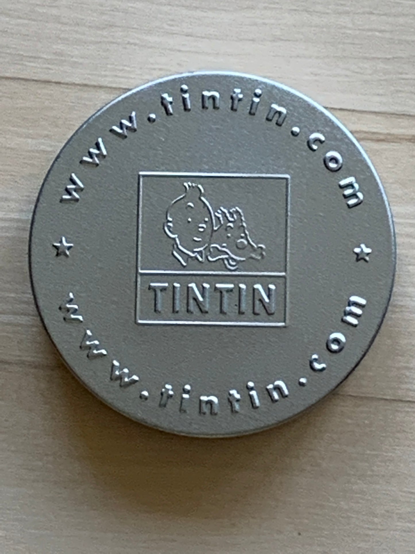 Tintin collectible metal coin with engraved logo and www.tintin.com website, from The Seven Crystal Balls game