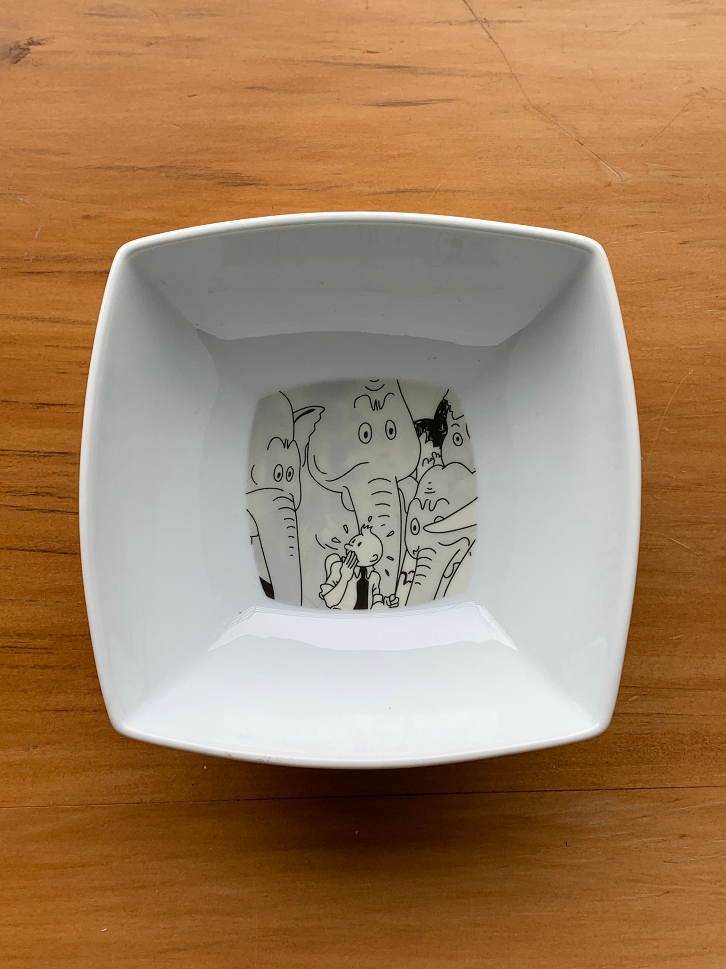 Tintin and elephants illustrated on white square bowl, part of Tintin tableware collection