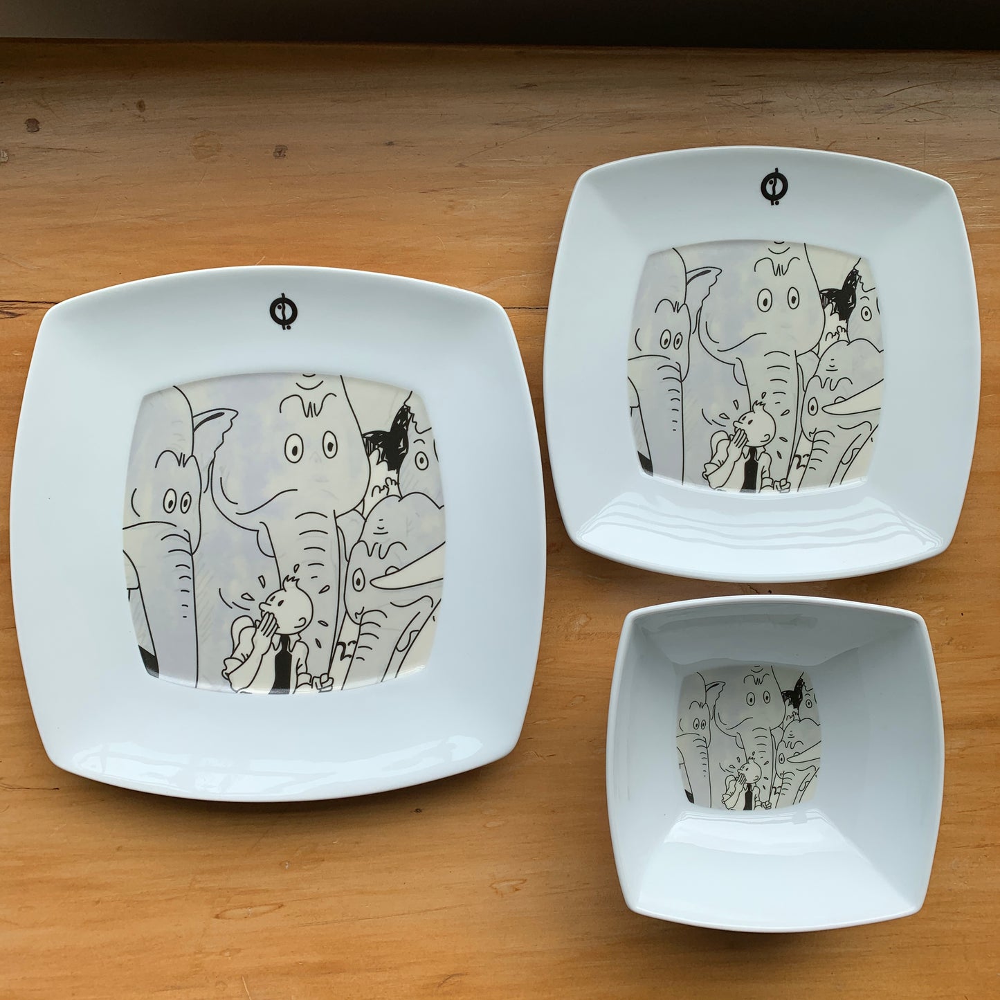 Tintin and Elephants tableware set featuring dinner plate, salad plate, and bowl with cartoon elephant designs on white stoneware