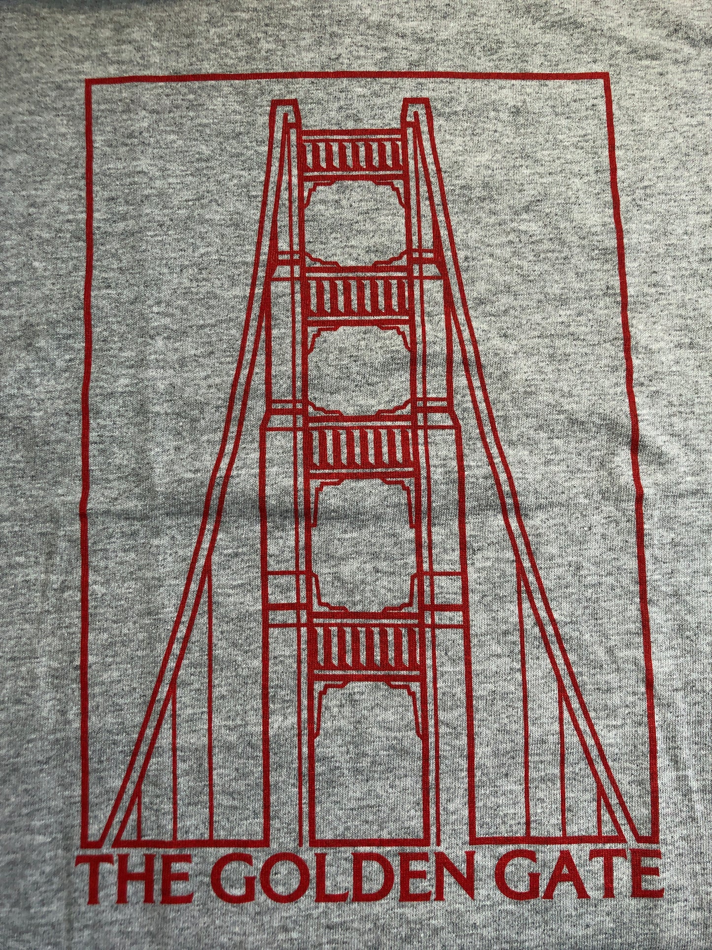 Golden Gate Bridge tower design on gray kids' t-shirt, with red line art and "The Golden Gate" text