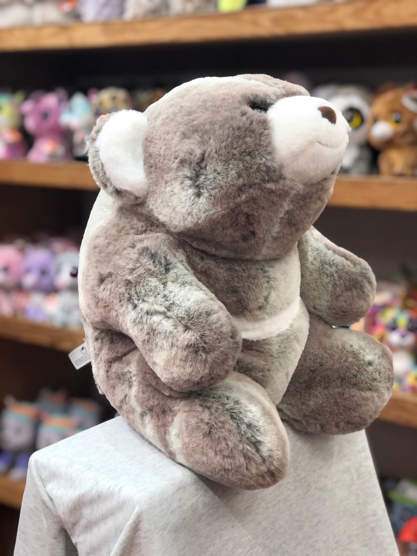Gund Snuffles two-tone gray and brown plush teddy bear on display, showcasing its soft texture and unique crescent design