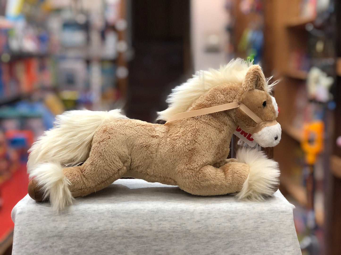Gund Fanning tan horse plush toy with white mane and tail, displayed in toy store setting
