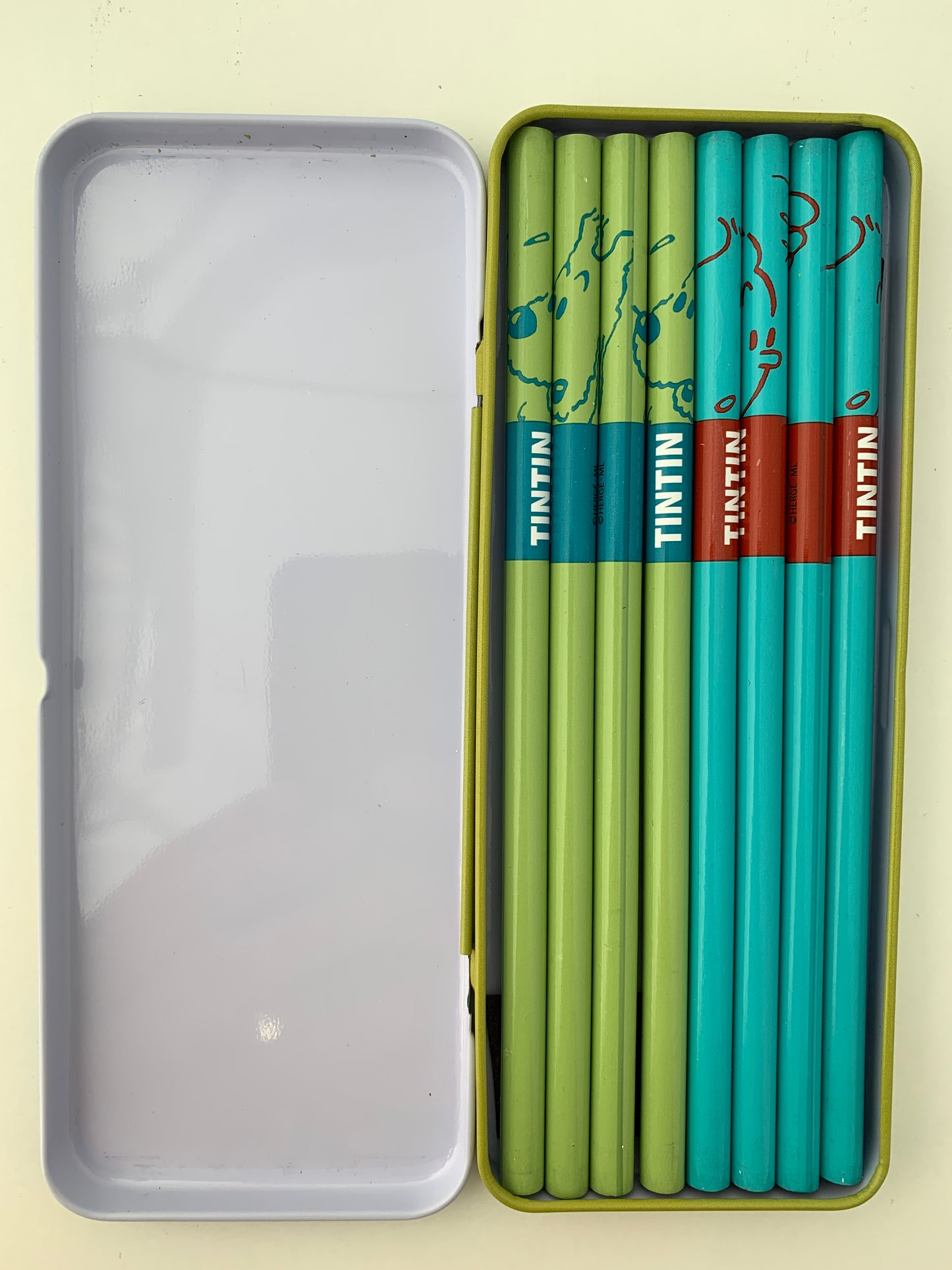 Tintin and Snowy pencil set in metal case, featuring 8 colorful HB pencils with character designs and Tintin logo