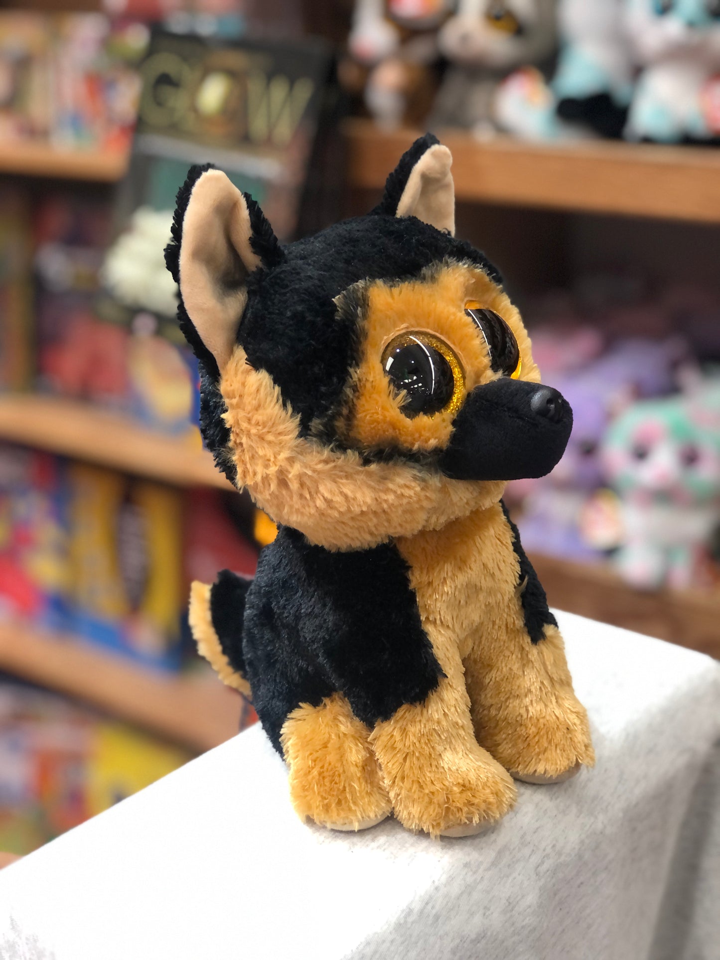 Ty Beanie Boo Spirit German Shepherd plush with black and tan fur, large golden eyes, sitting on display in toy store
