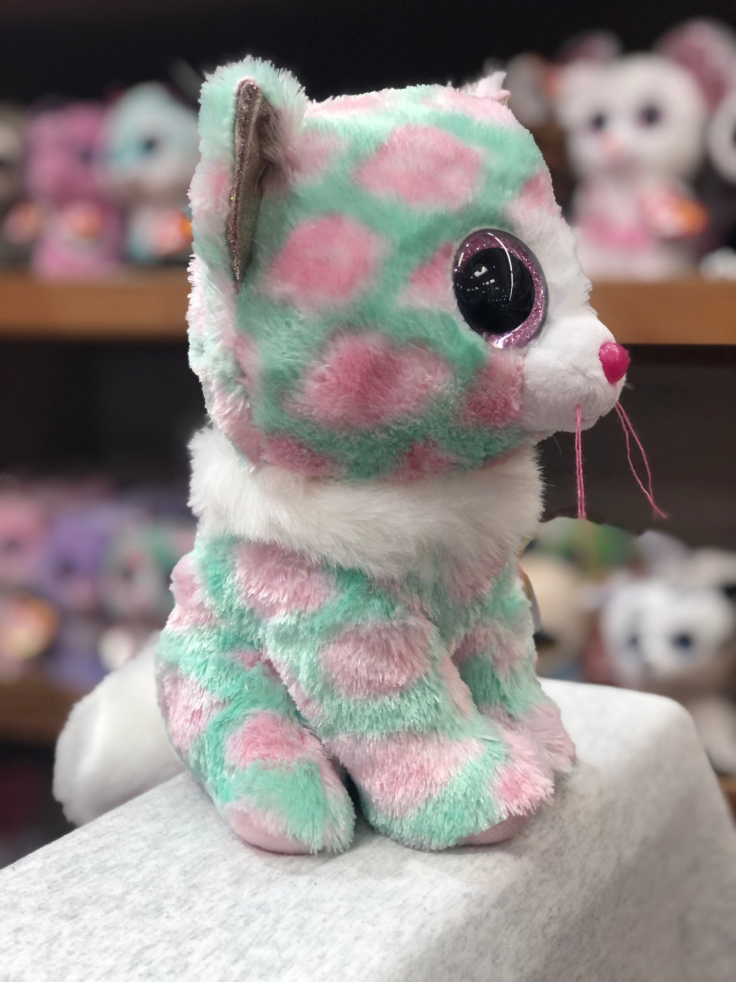 Ty Beanie Boo Opal cat plush with pastel green and pink fur, white collar, large sparkly eyes, and pink nose