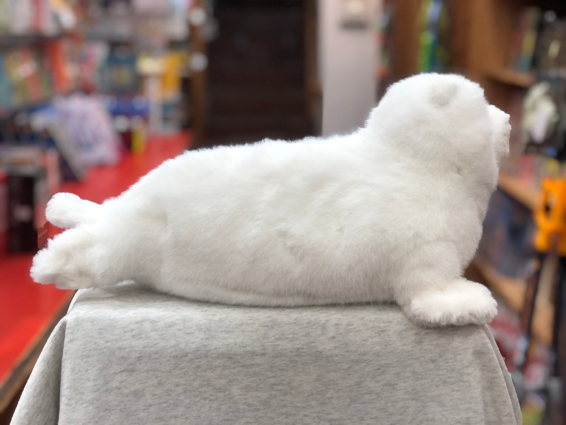 Adorable white harp seal plush toy with realistic features, displayed in store setting