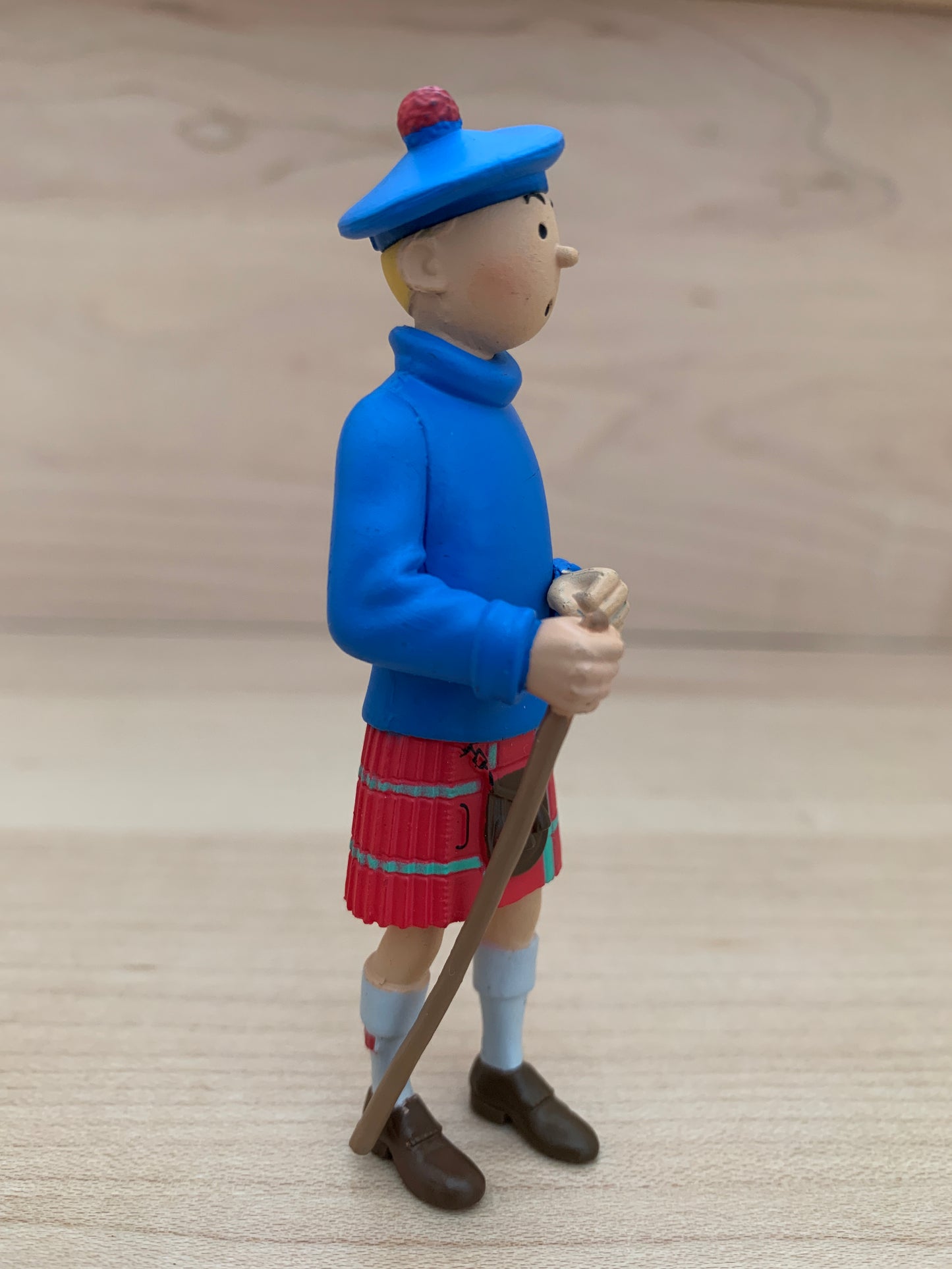 Tintin 8cm mini figure in Scottish highland dress with blue sweater, red kilt, and tam o' shanter, holding walking stick